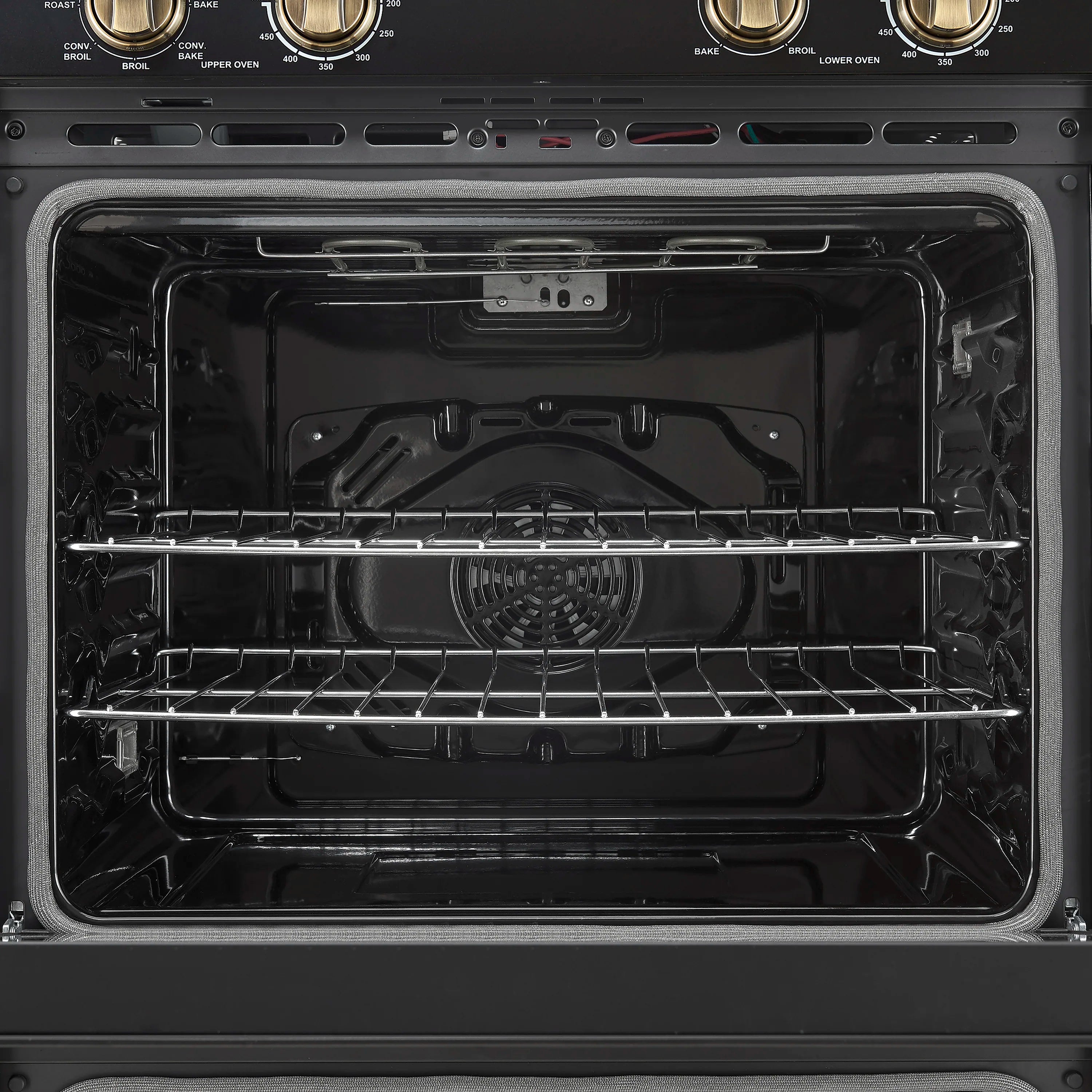 Open upper oven cavity with racks and heating elements inside, black double oven