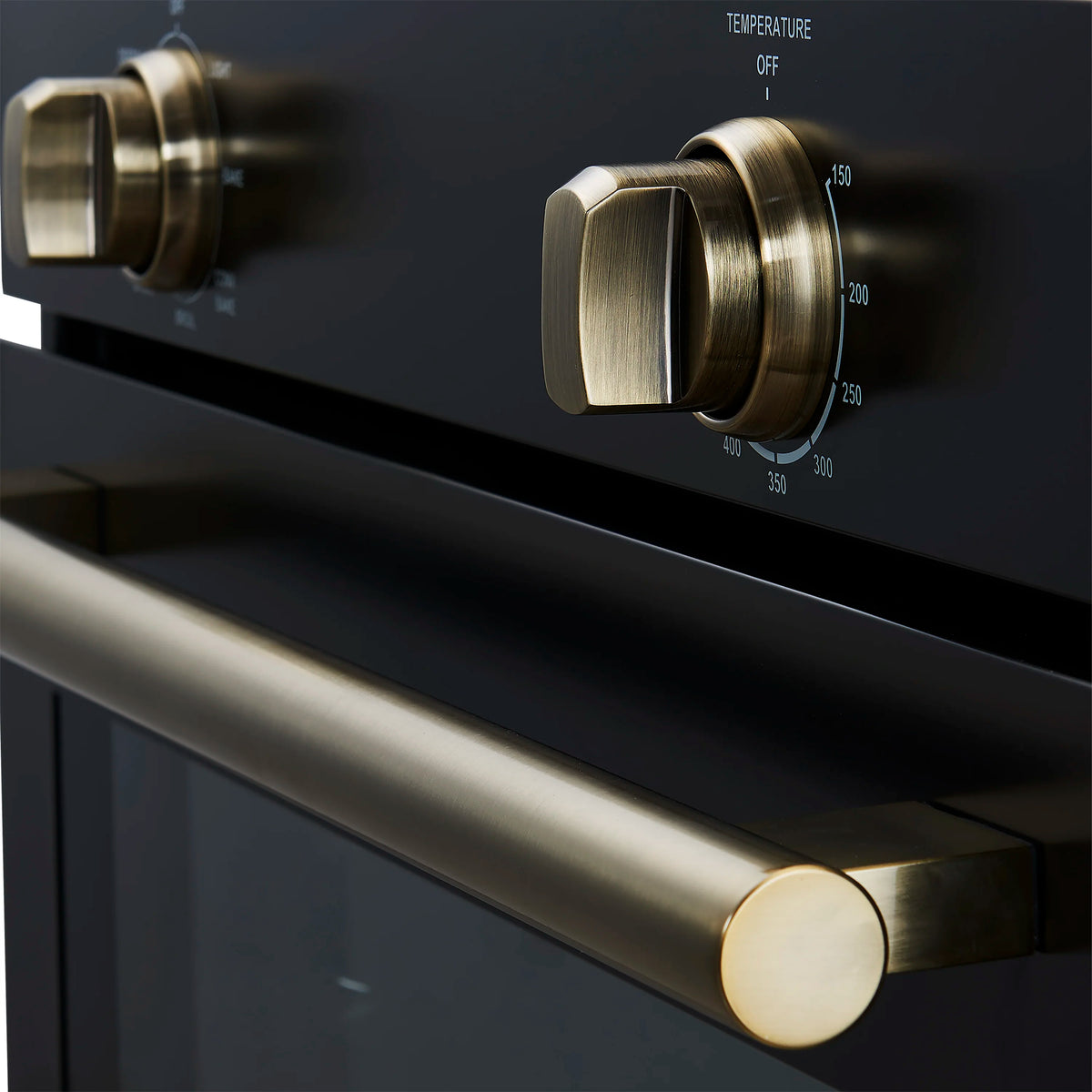 Wall oven close-up of antique brass handle and temperature control knob