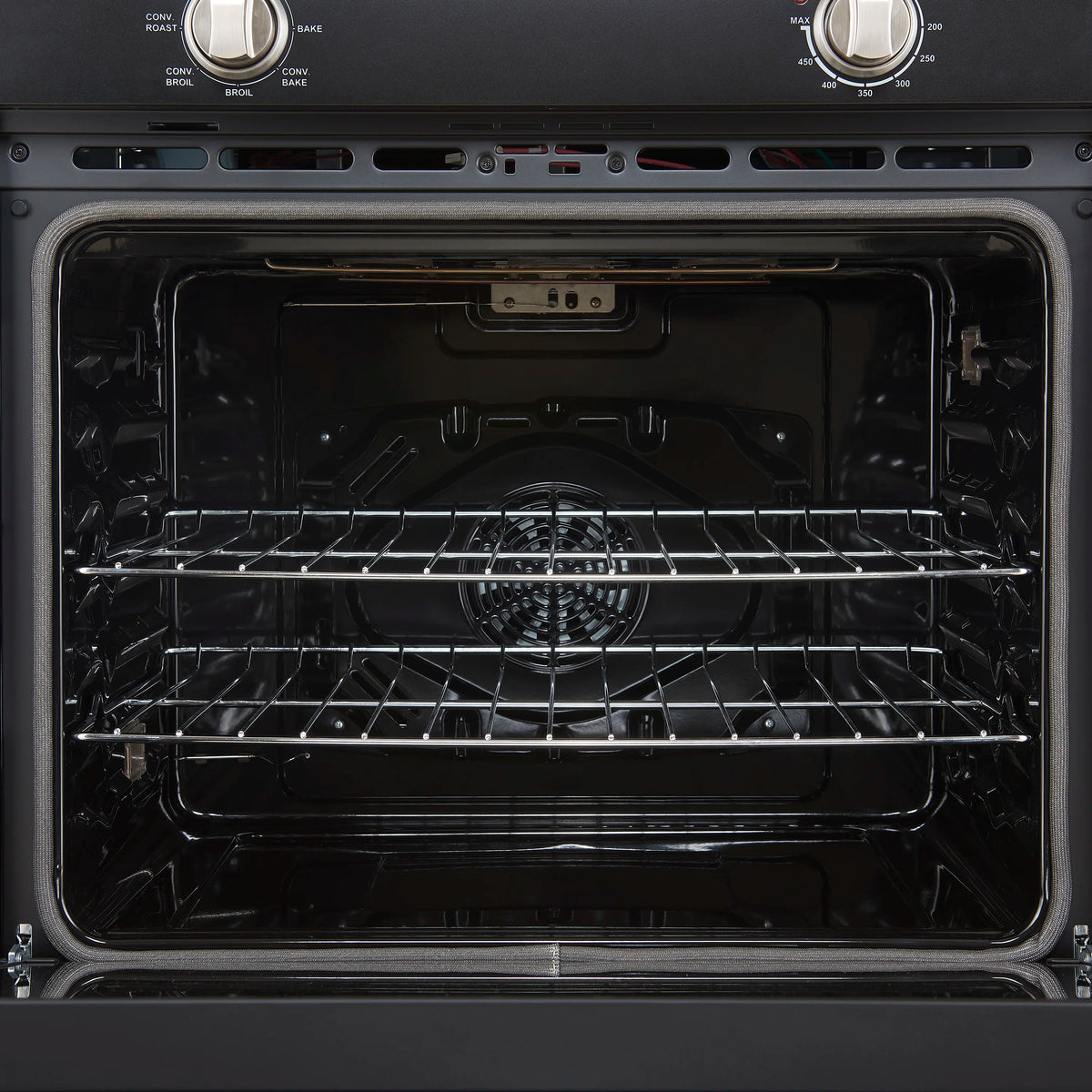 Wall oven interior with two oven racks and convection fan at the back