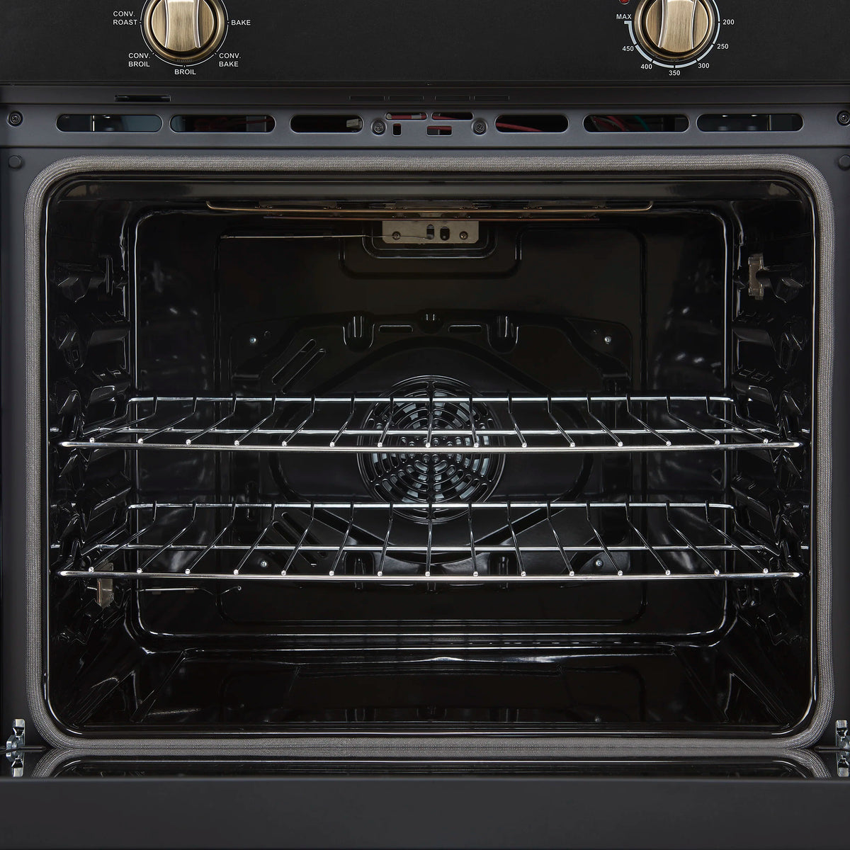 Wall oven interior with metal racks and heating element inside the black cavity