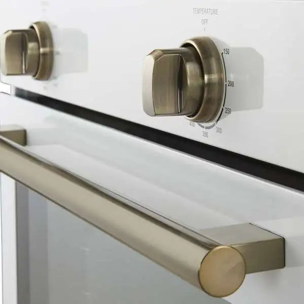 Wall oven brass-toned handle and round temperature control knob on white panel