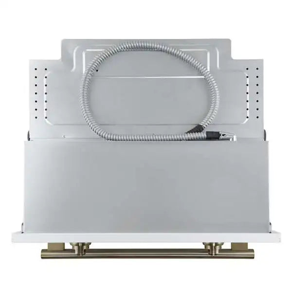White wall oven with brass-toned trim and coiled flex gas conduit connection