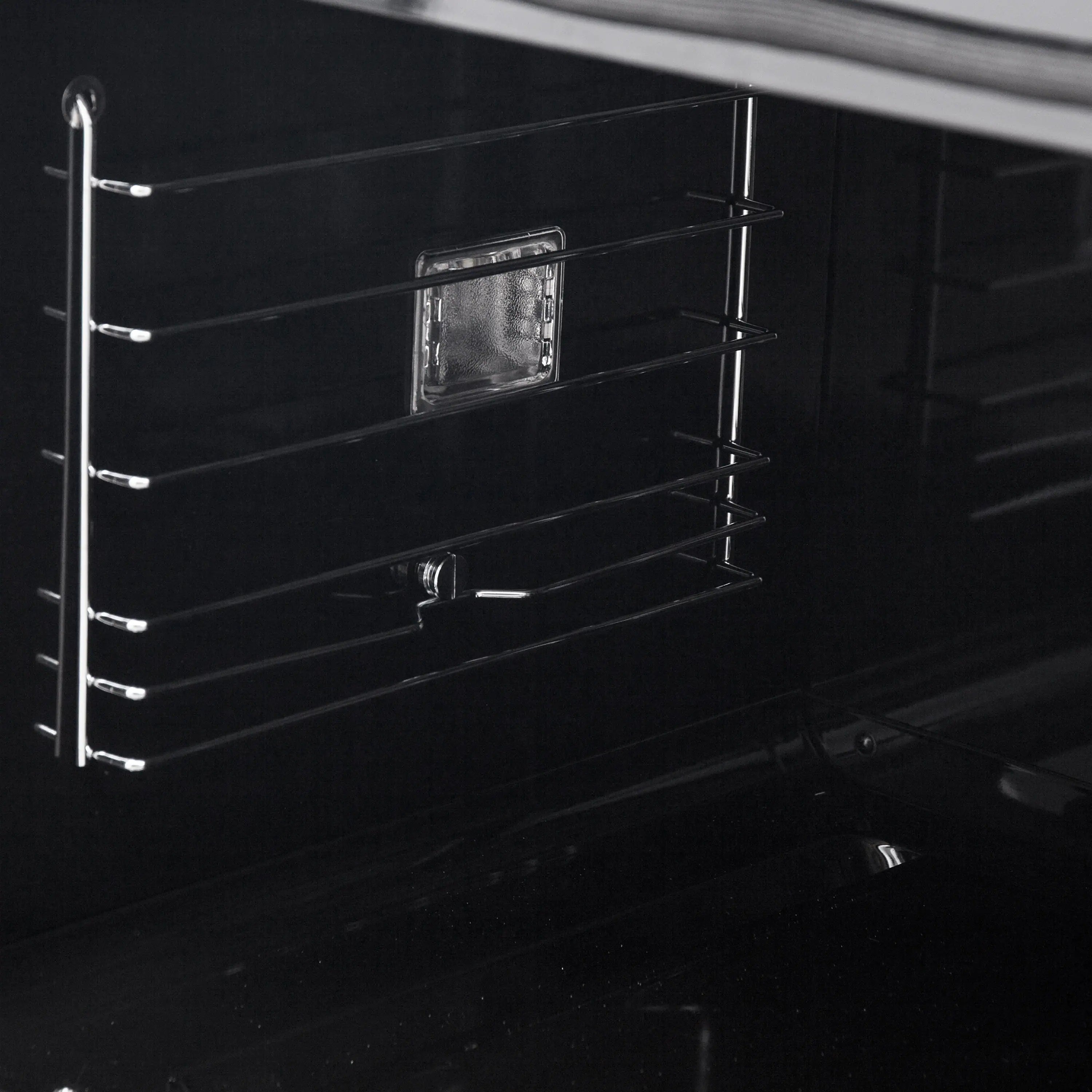 Black oven interior side with wire rack guides and small accessory shelf.