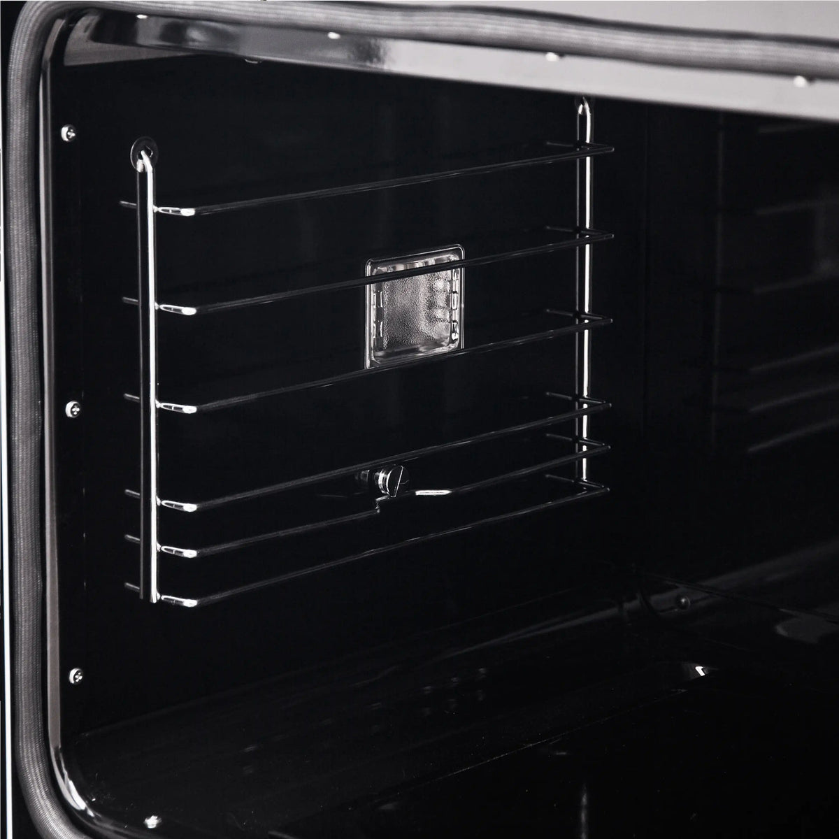Black oven cavity with wire rack shelves and central oven light housing