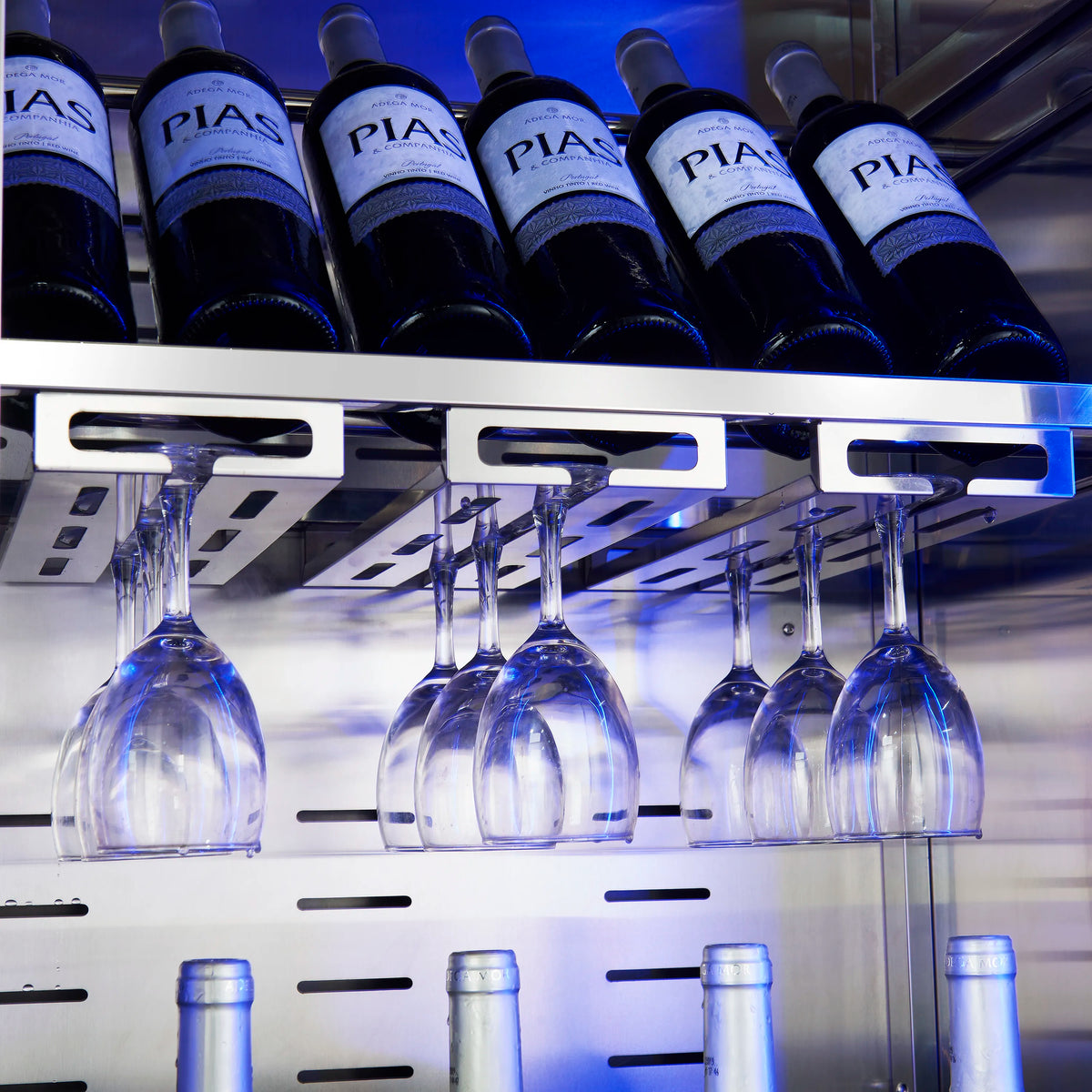 Wine cooler interior with hanging wine glasses beneath a blue-lit bottle shelf.