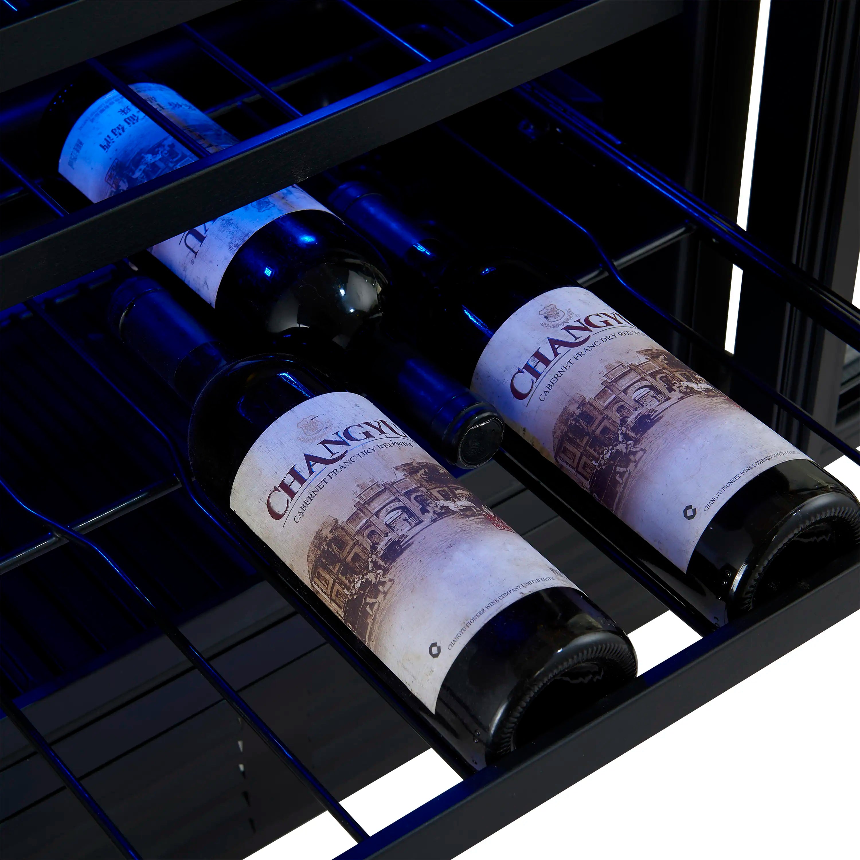 Wine and beverage cooler interior holding two dark wine bottles on wire shelves