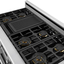 Close-up of black gas cooktop grates with burner caps on stainless range
