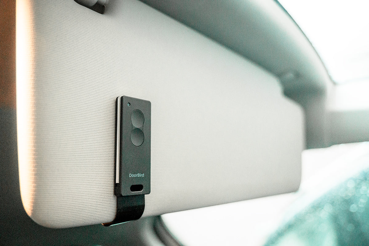 Dark gray key fob remote mounted on car interior panel