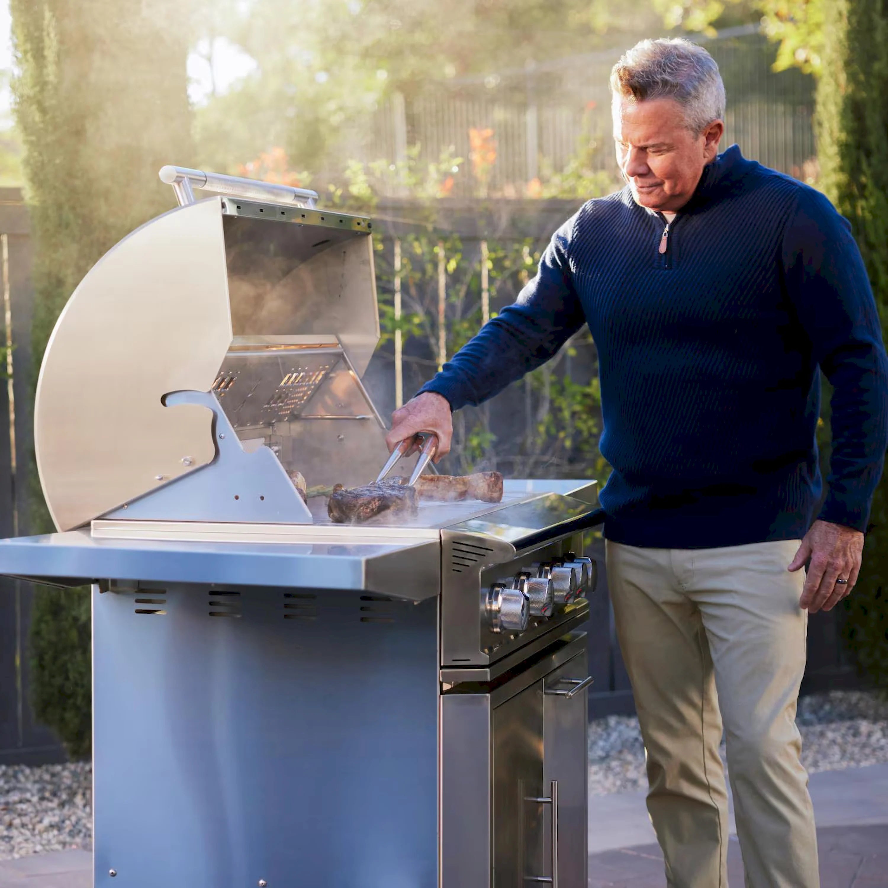 Stainless steel freestanding gas grill with open lid and front control panel