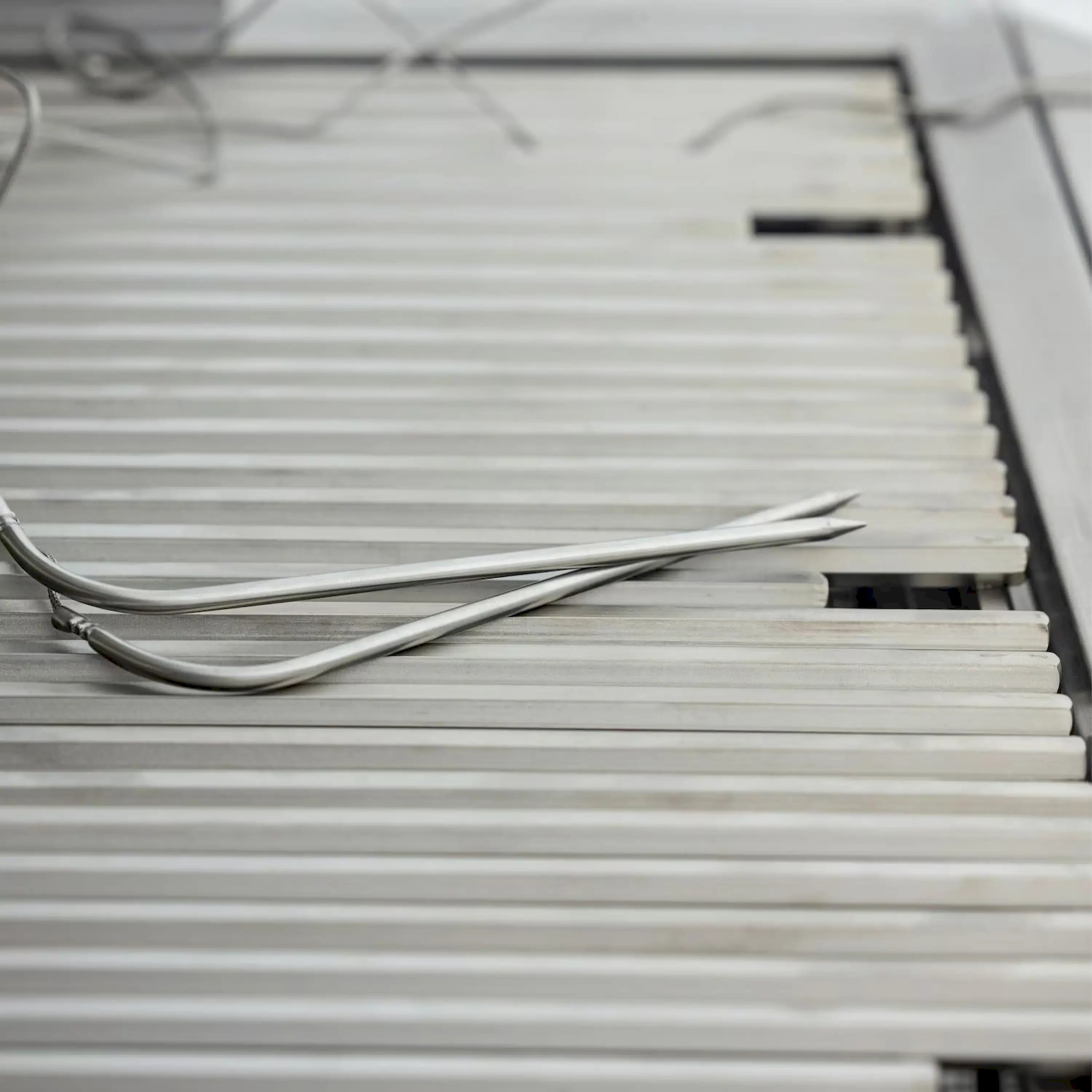 Stainless steel heat shield with wire ignition electrodes on the grill