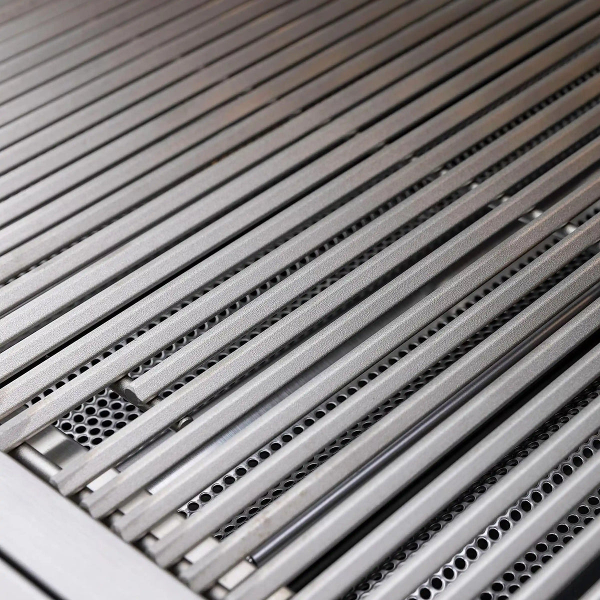 Stainless grill grates with evenly spaced rods and perforated heat shield below