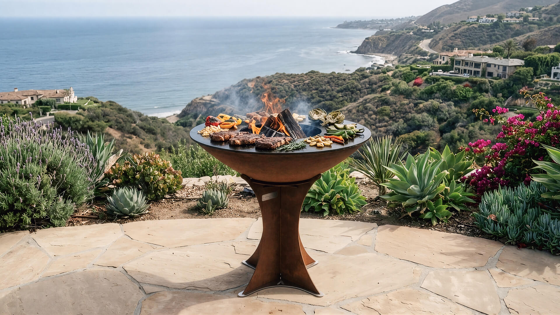 Corten brown outdoor flat-top grill on pedestal base, cooking on open flame