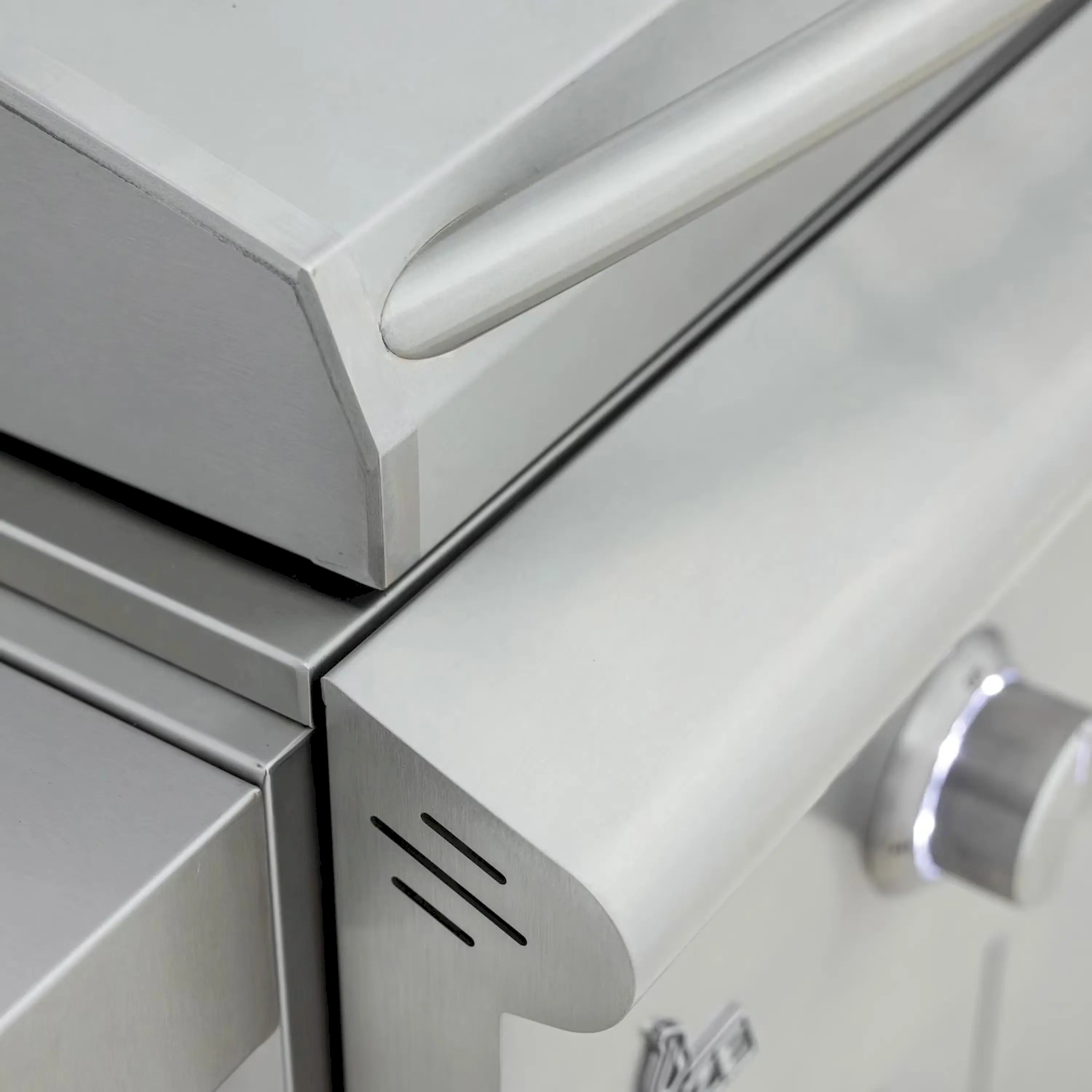 Stainless steel grill corner with vented panel and round control knob