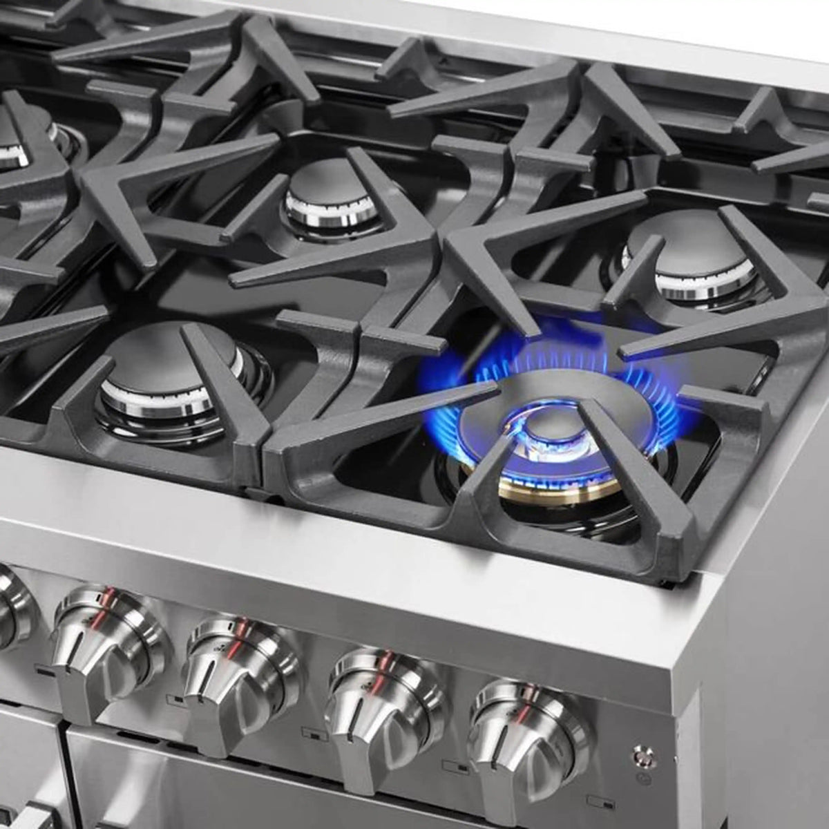 Stainless steel gas cooktop with burner grates and blue flame
