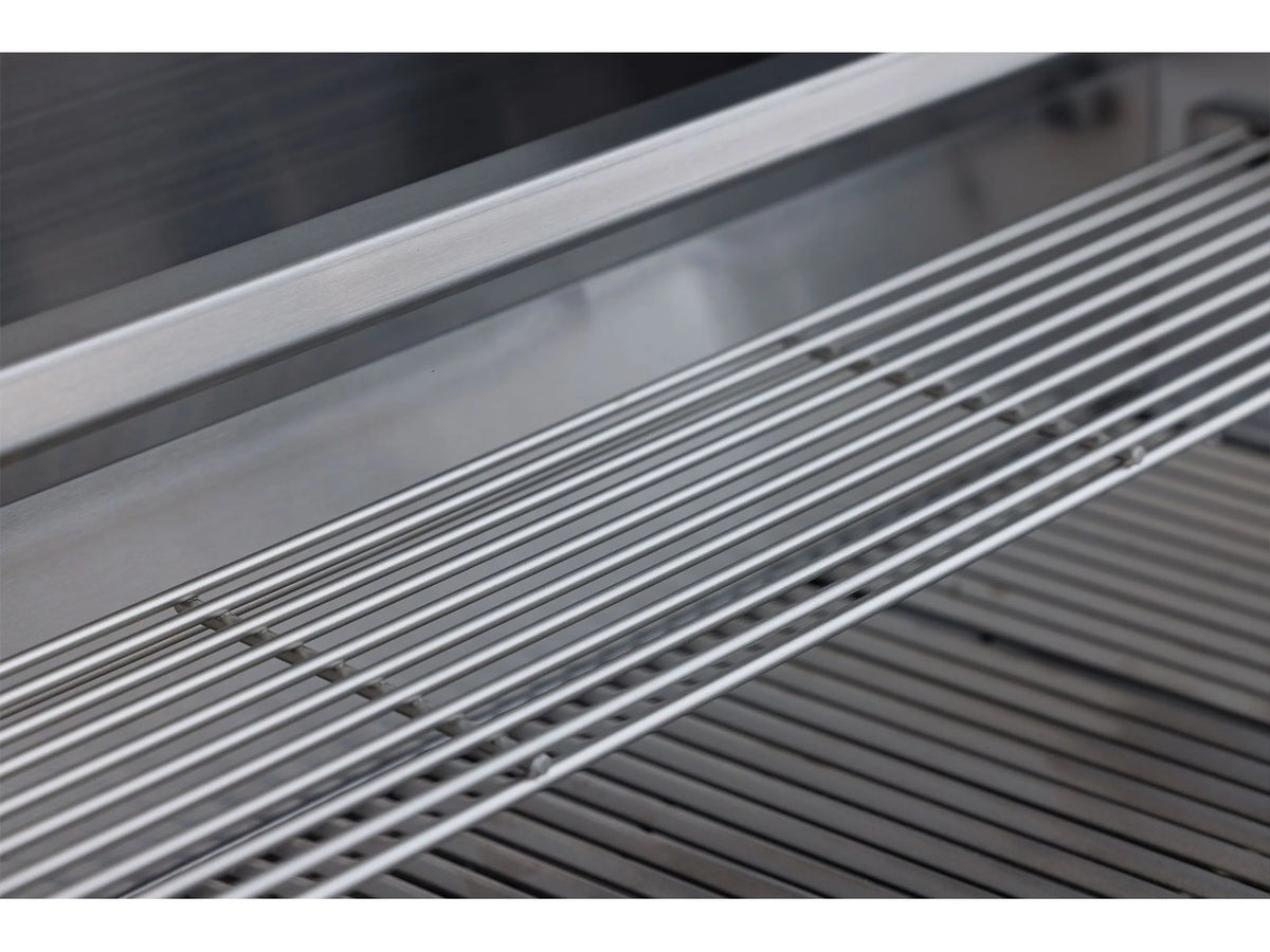 Close-up of stainless grill cooking grates and burner area inside the hood