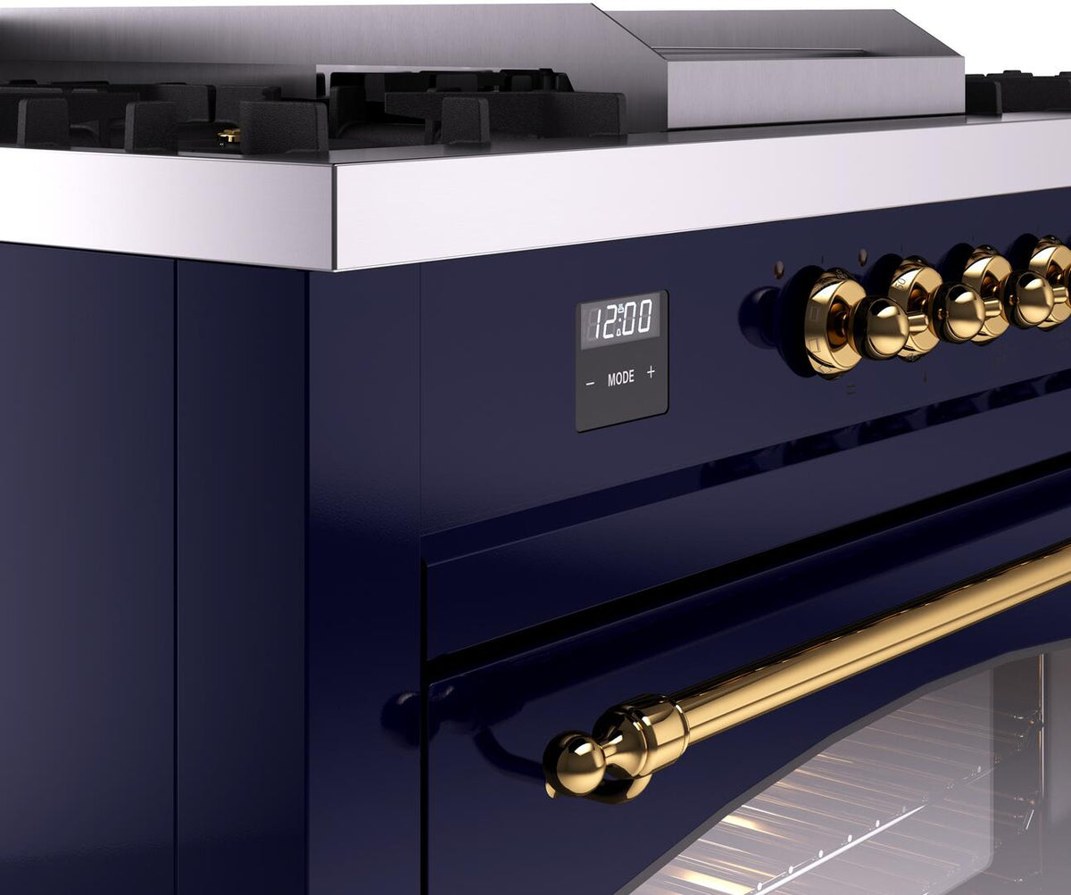 Close-up of midnight blue range control panel with gold brass knobs and display