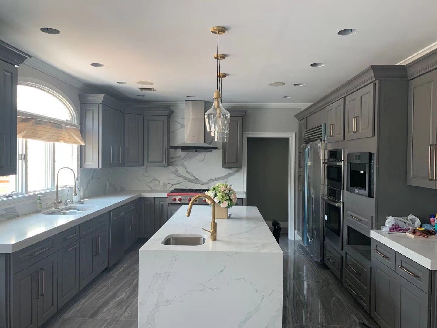 Stainless steel decorative range hood ceiling cover installed over kitchen island.