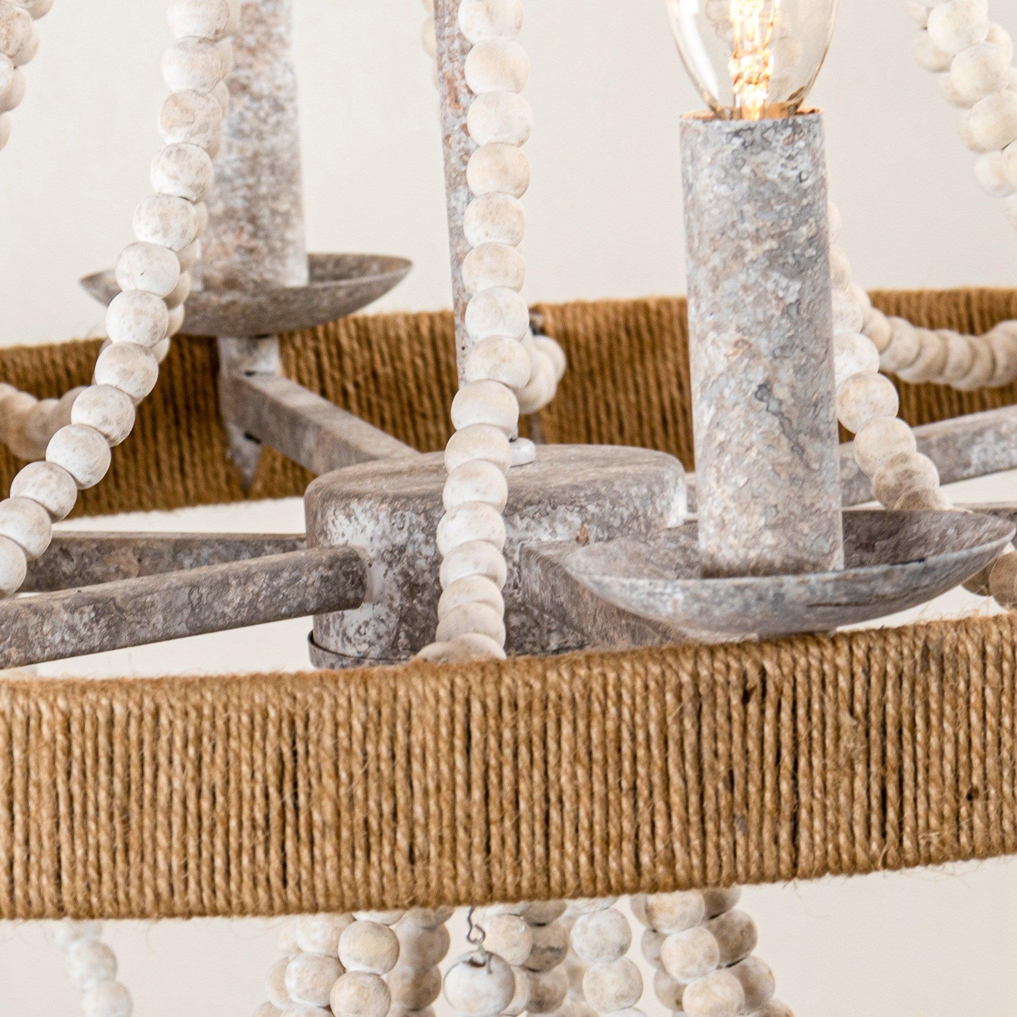 Close-up of wood bead chandelier frame with white bead strands and gray bowl holders