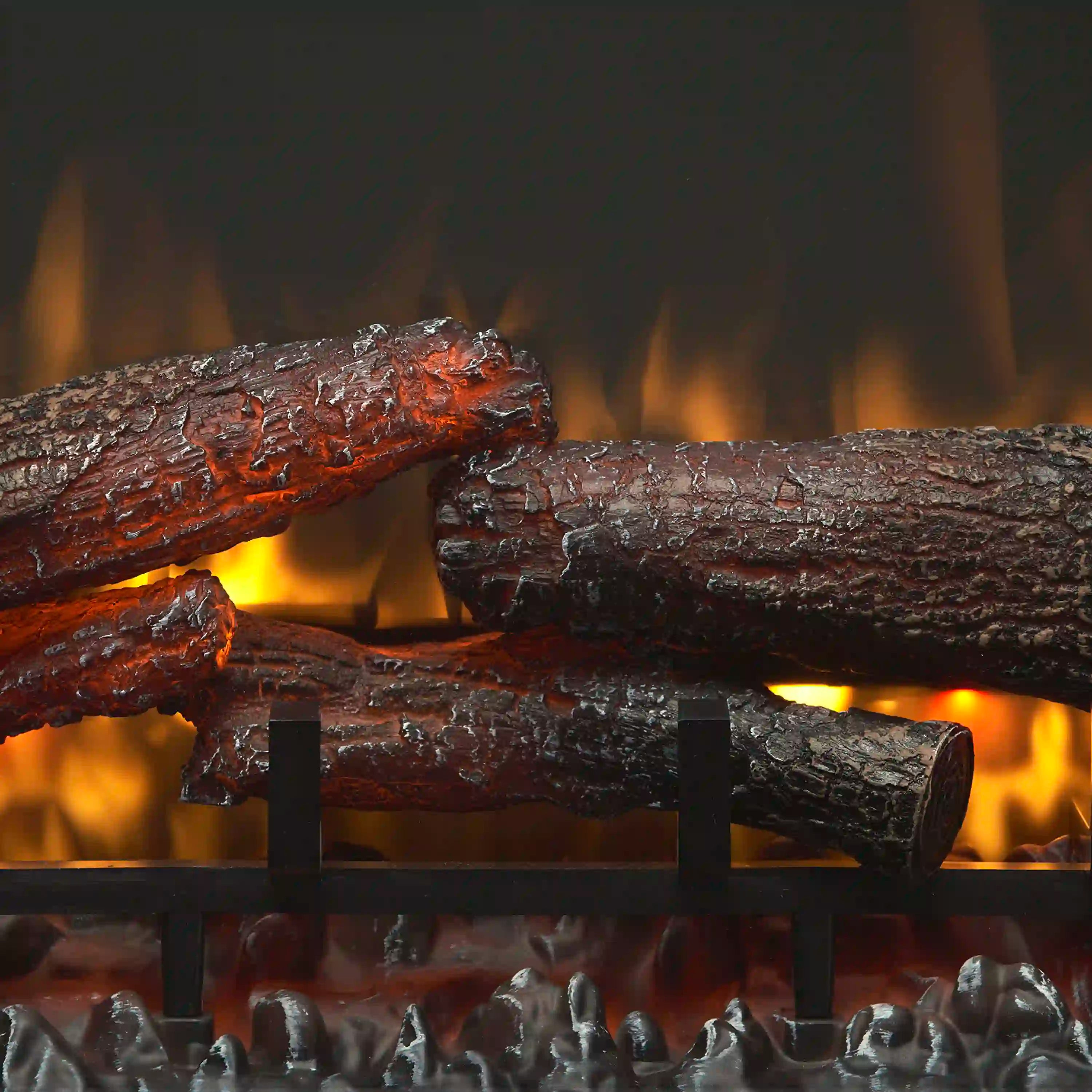 Close-up of glowing electric fire logs with ember bed and orange flame effect