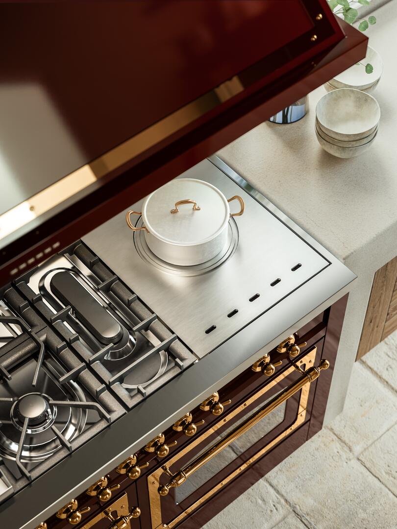 Antique white gas range with black grates, copper trim, and French-top griddle