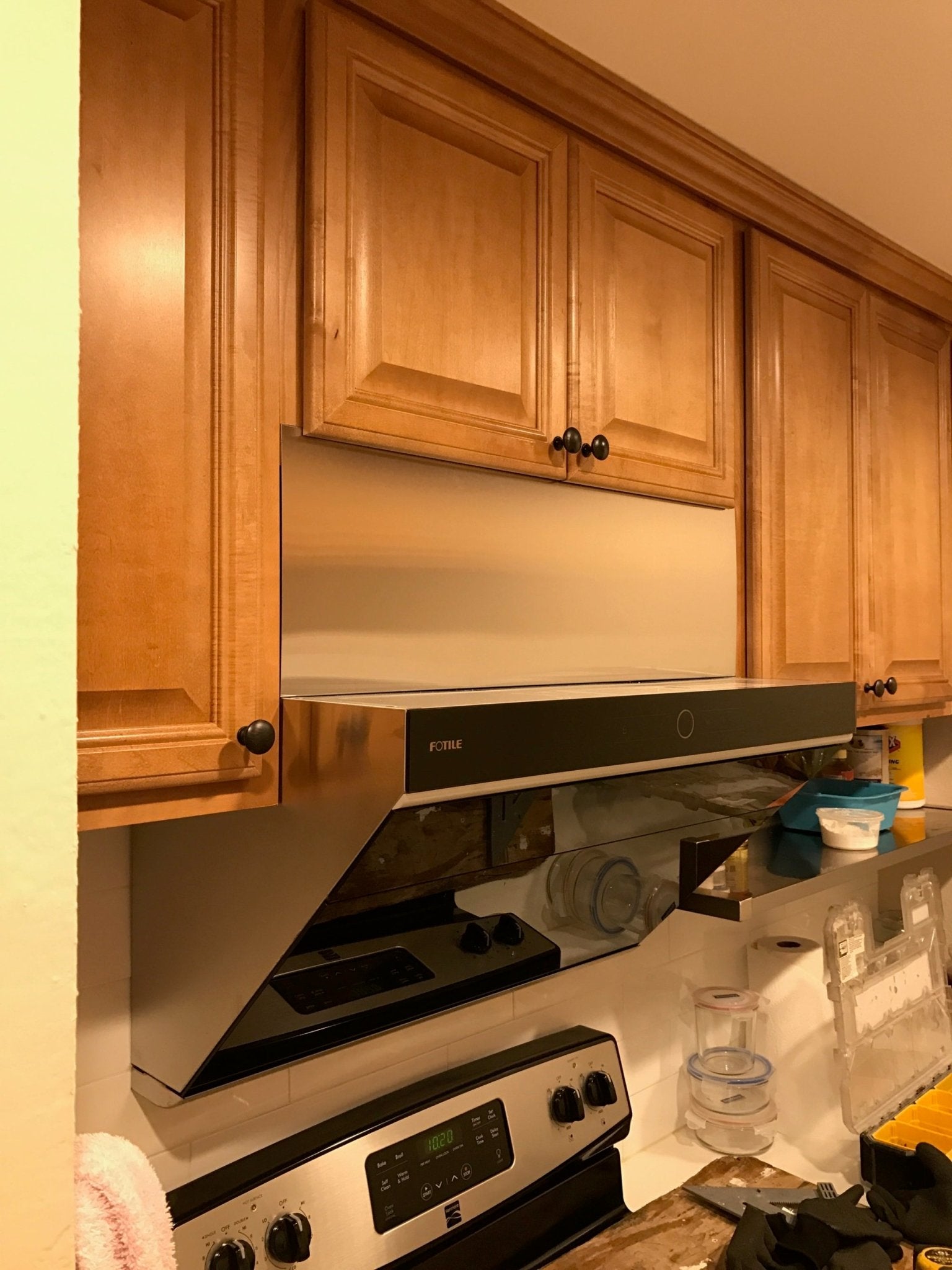 Black decorative vent panel on a slant range hood, integrated rectangular face