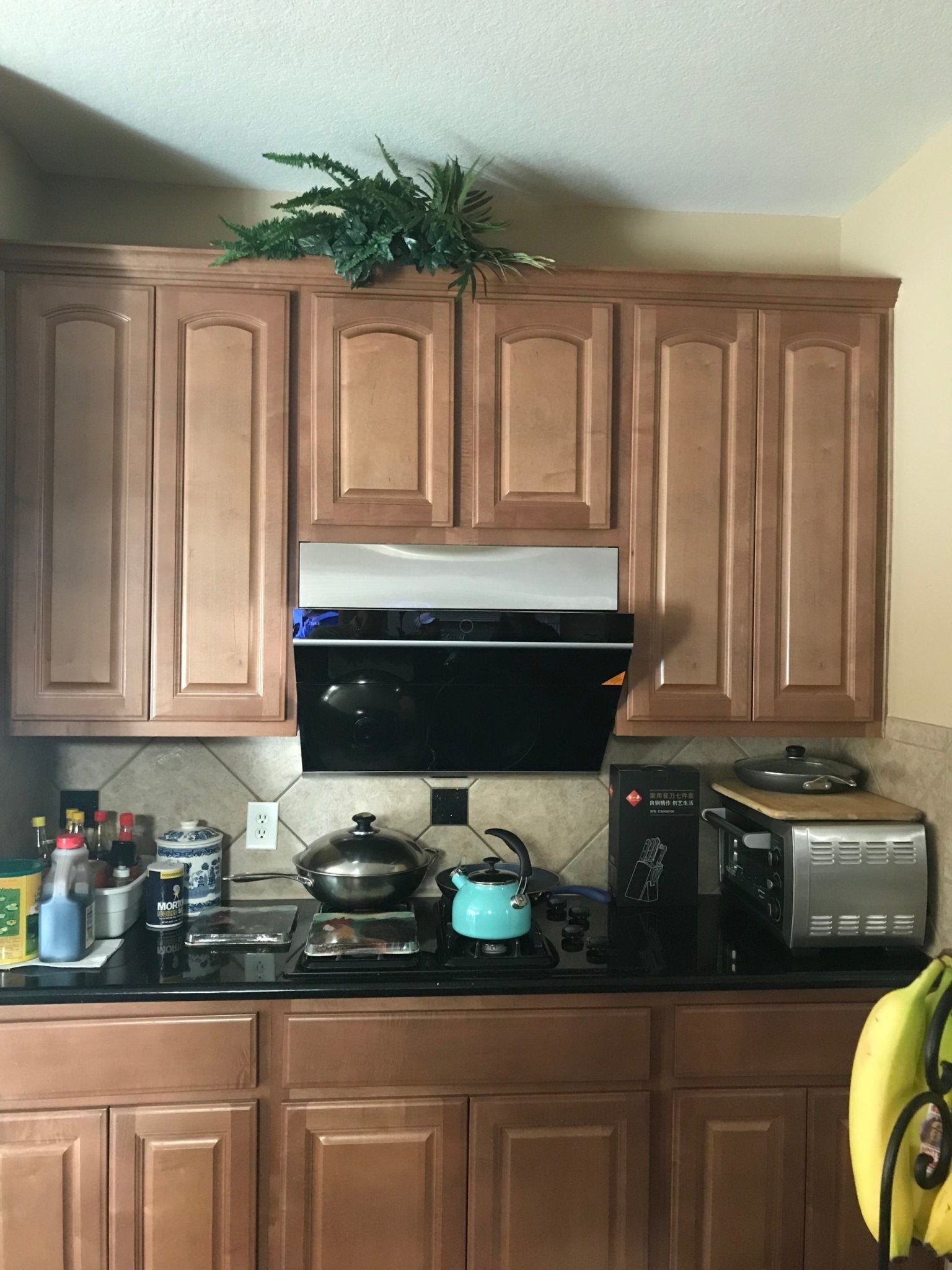 Black decorative vent panel on a slant range hood, rectangular with side trim