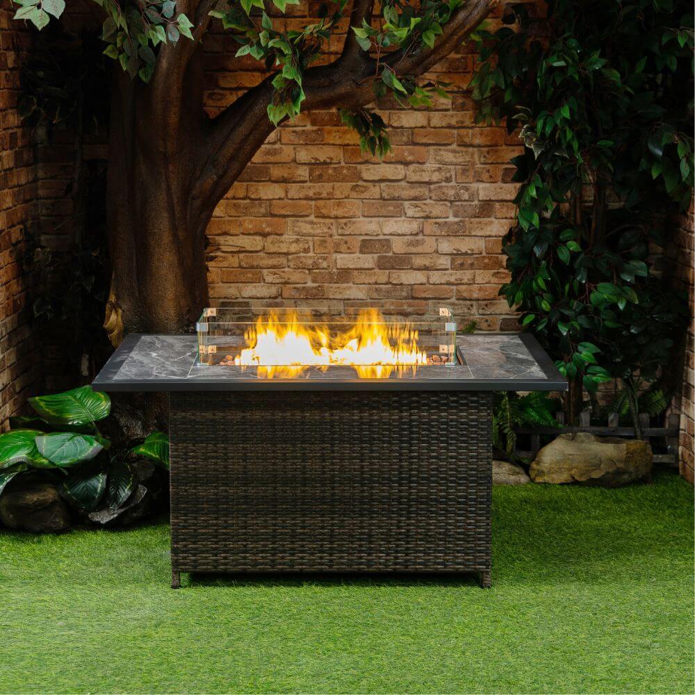 Brown wicker propane gas fire pit with flame burner outdoors