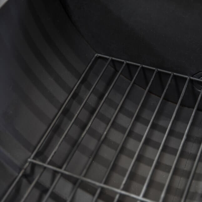 Interior grate and firebox walls inside black barrel wood burner firepit