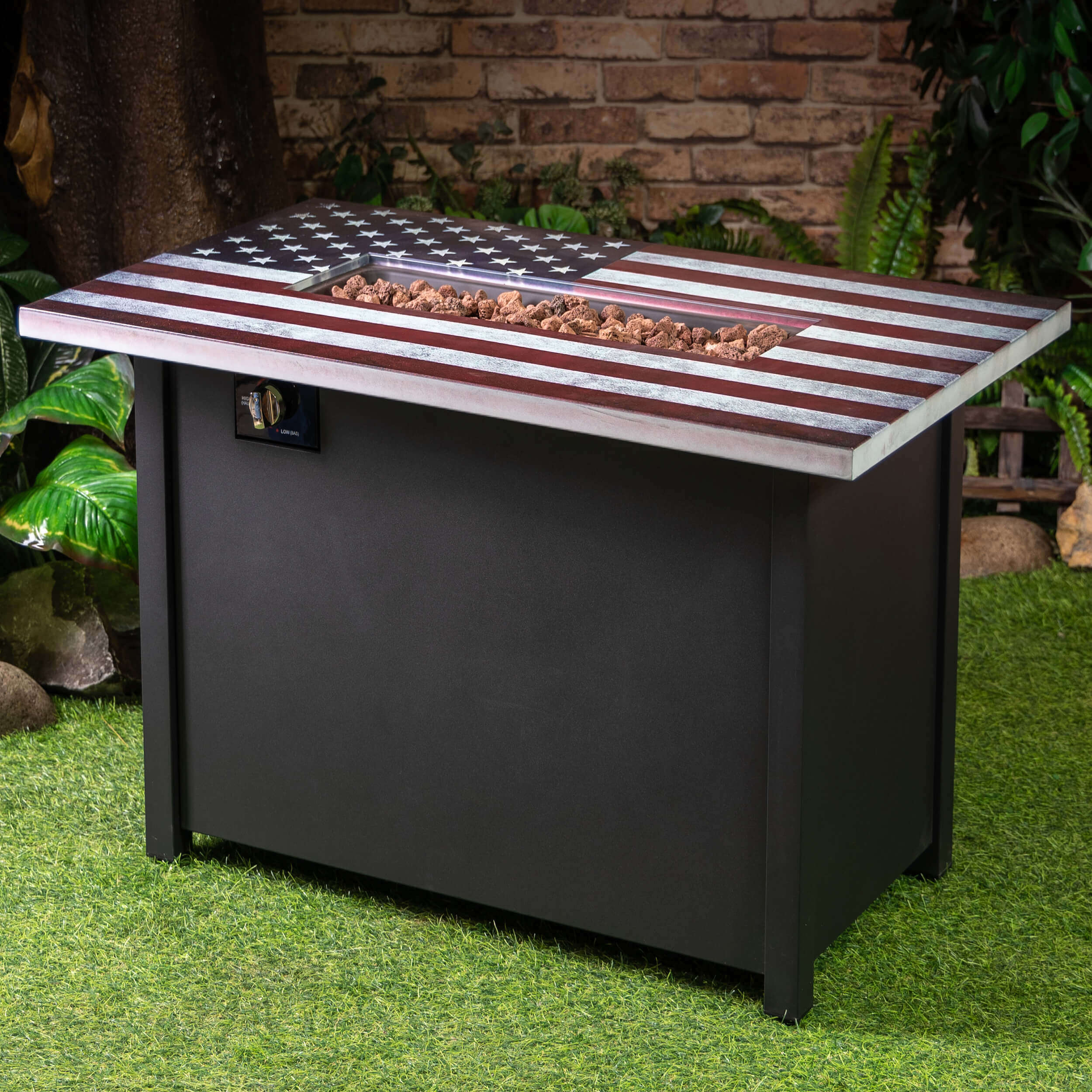 Outdoor propane fire table with open American flag lid, fire grate, black cabinet