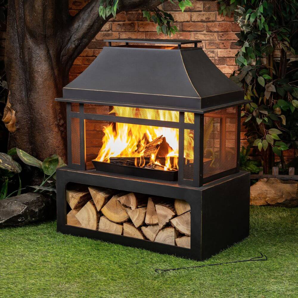 Black metal wood burner fireplace with burning logs behind the open glassless front