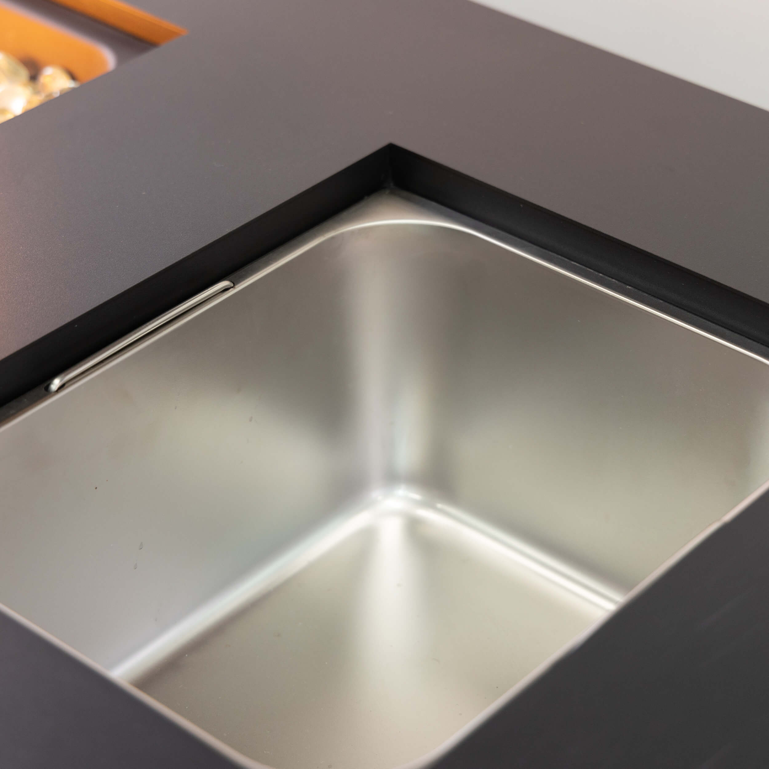 Stainless steel ice bucket basin inside a black outdoor firetable