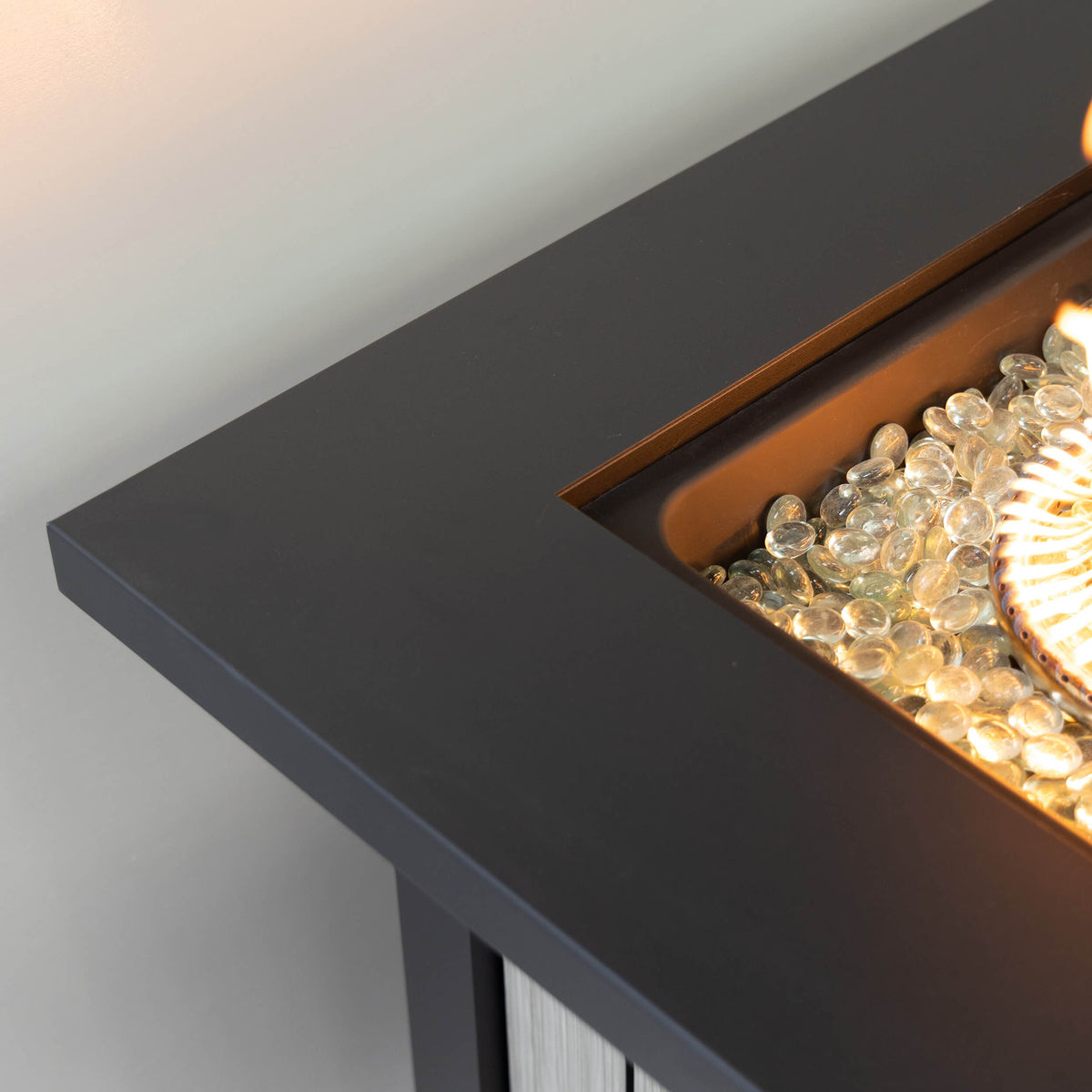 Close-up of lit fire area inside dark rectangular firebox with glowing fuel