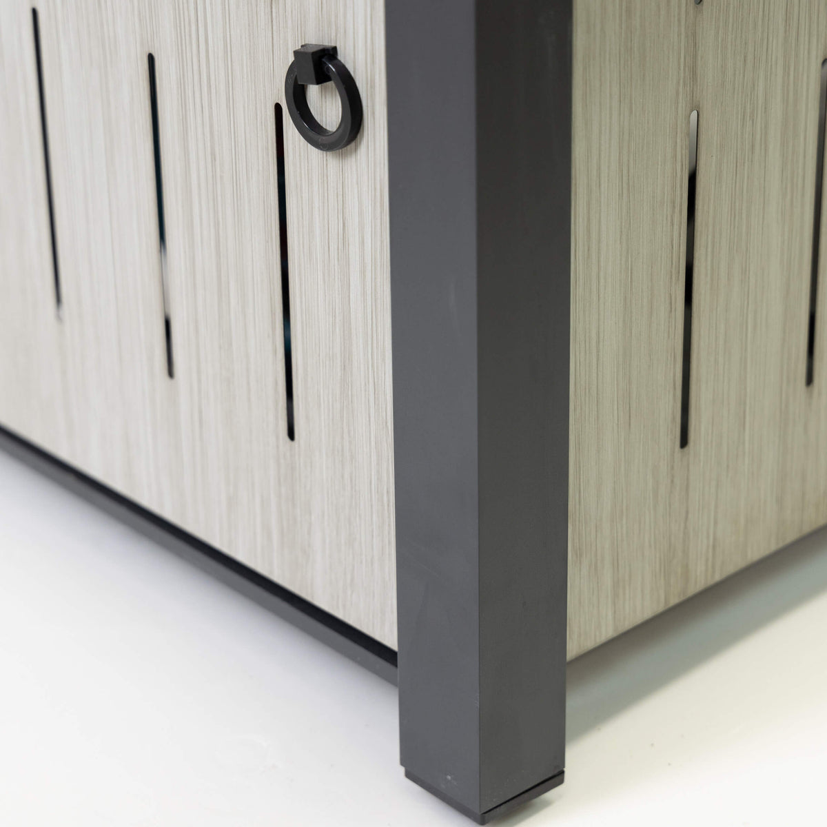 Rectangular firetable cabinet corner with ring handle on light wood slatted doors