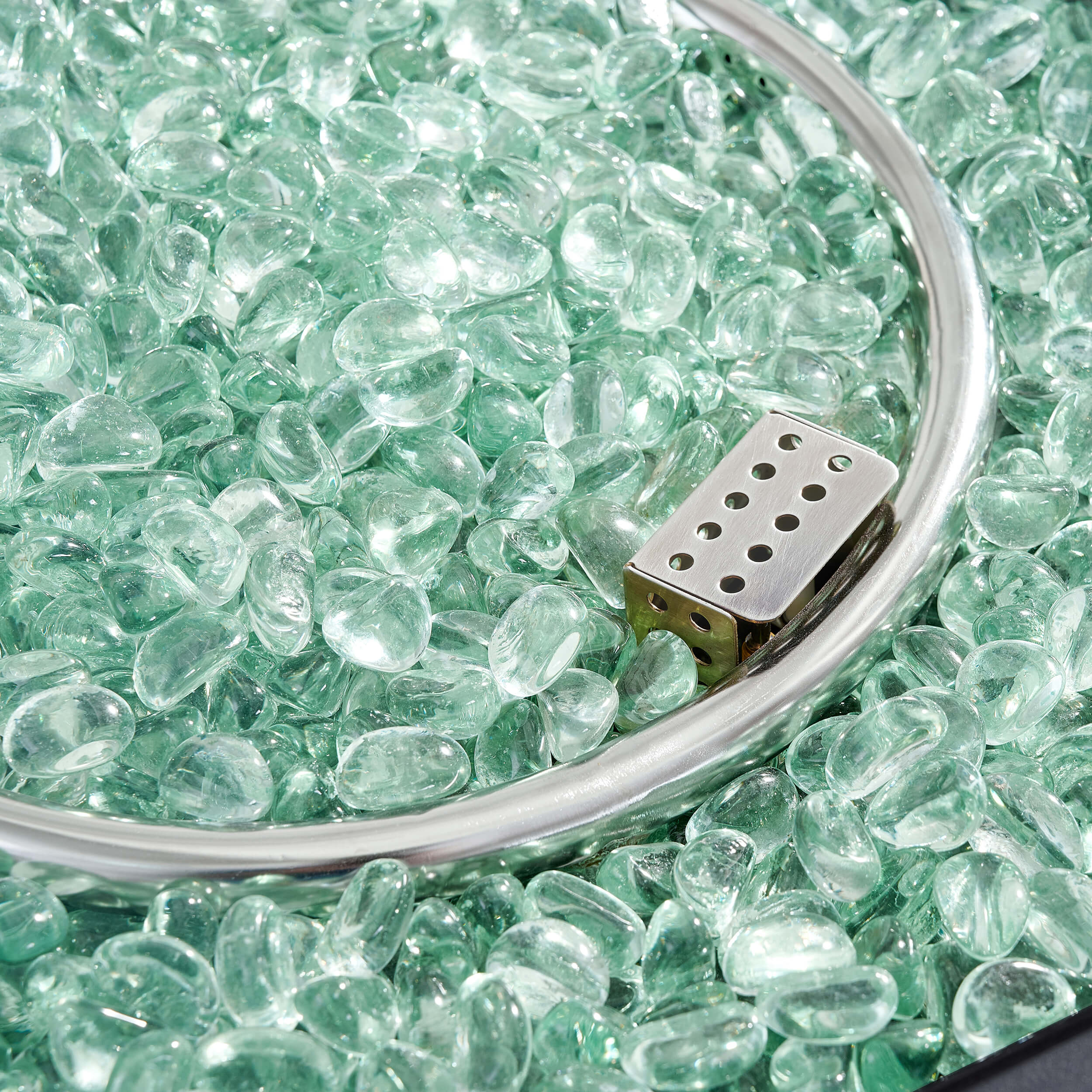 Green glass fire beads in metal burner bowl
