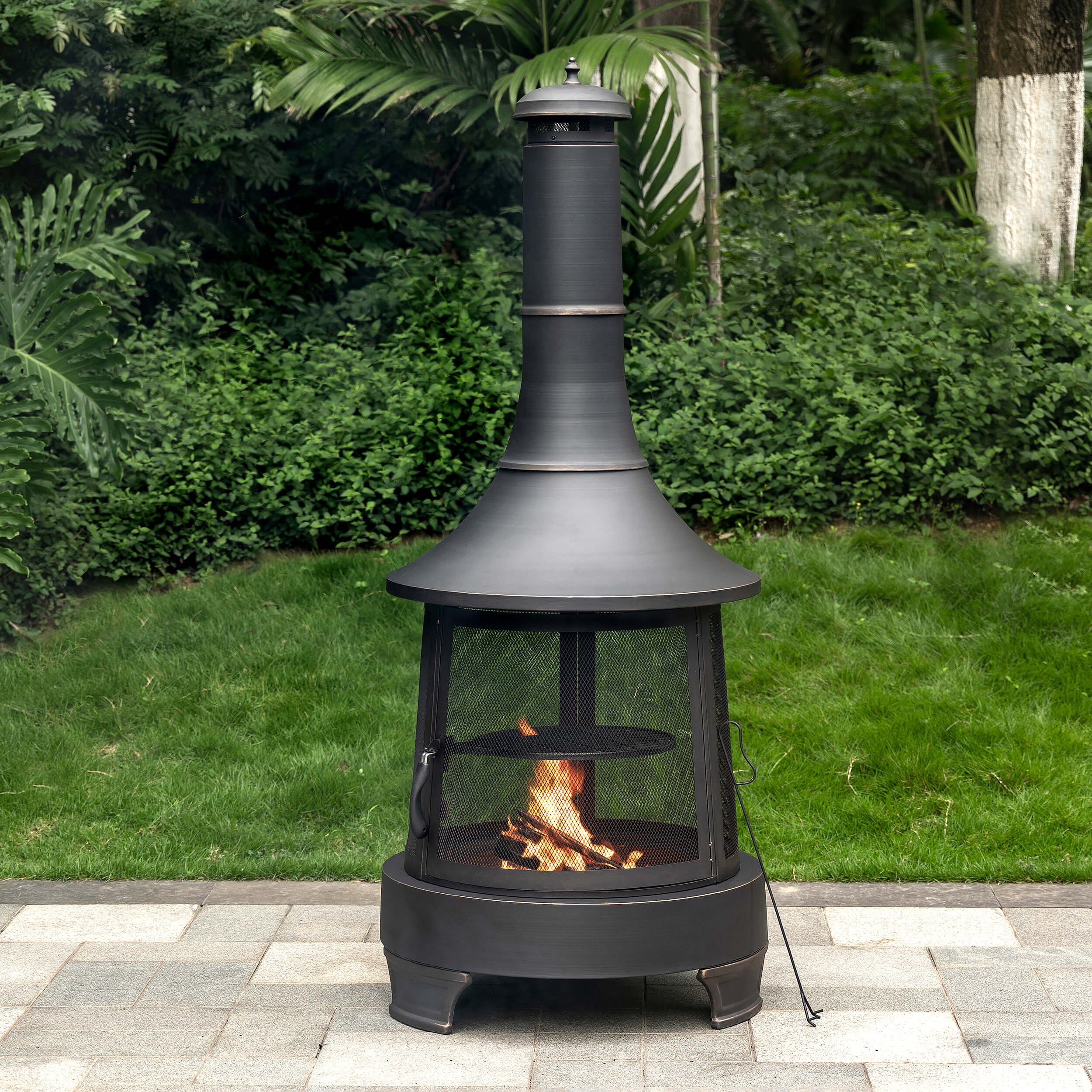 Outdoor chimney wood burner firepit with visible flames behind the mesh door