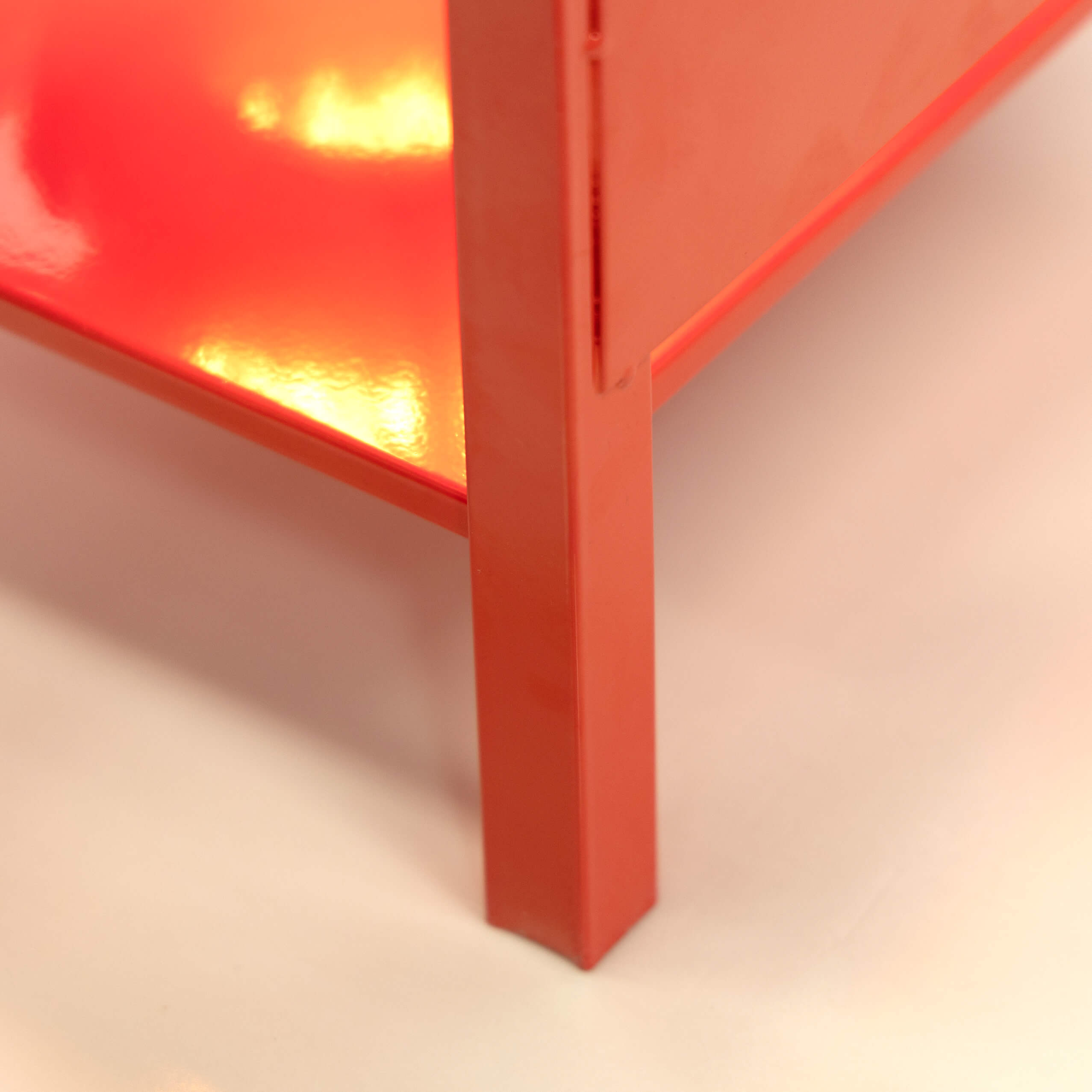 Red metal support leg and corner detail of outdoor propane burner stand