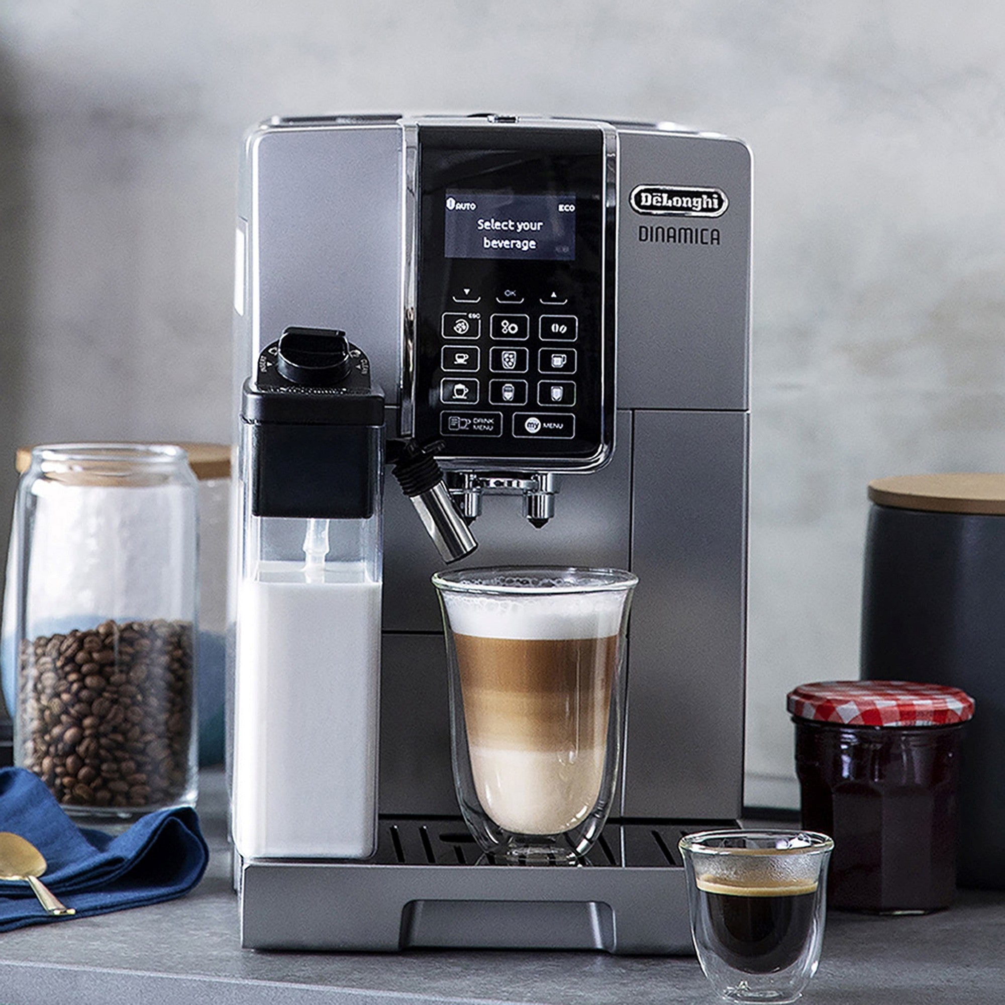 Silver espresso machine dispensing a latte with froth into a cup