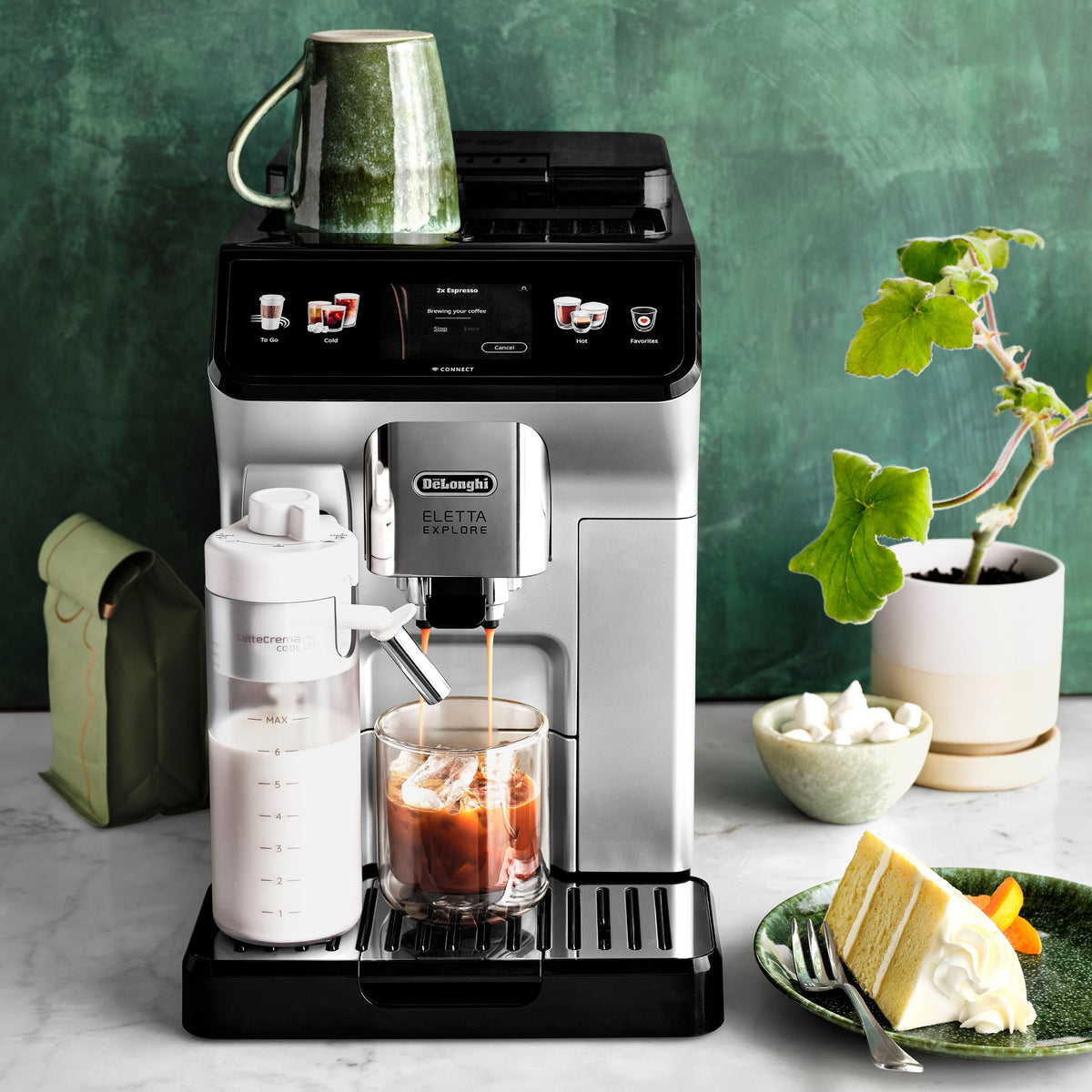 Fully automatic espresso machine dispensing coffee into a glass, with cold brew containers