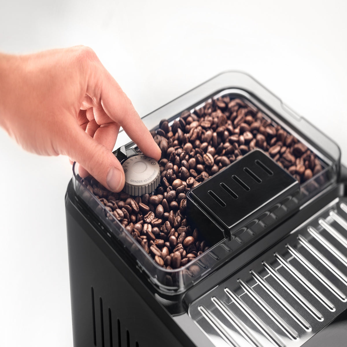 Coffee bean hopper close-up with grinder adjustment knob on fully automatic espresso machine