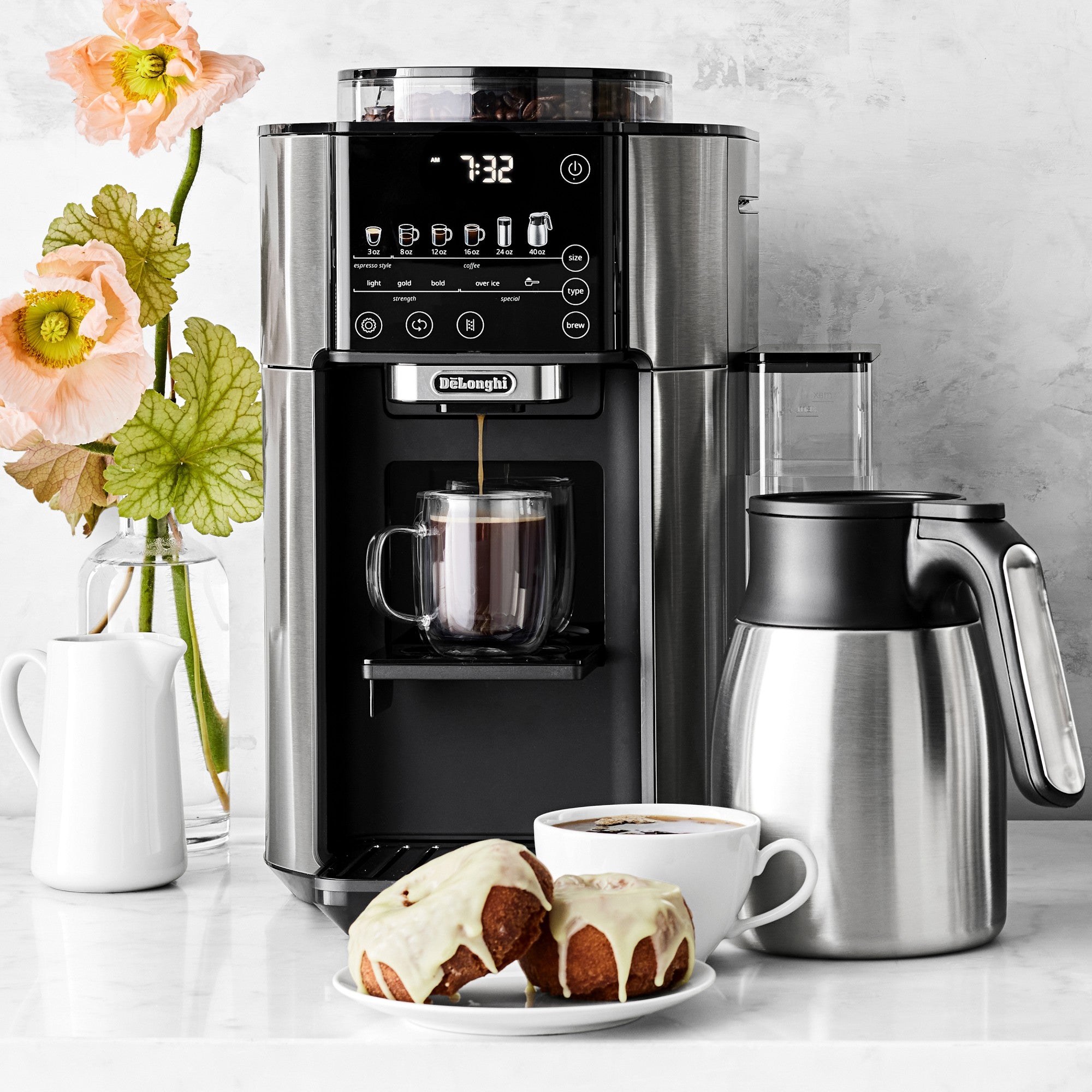 De'Longhi TrueBrew coffee maker with thermal carafe, cups, and pitcher on the counter