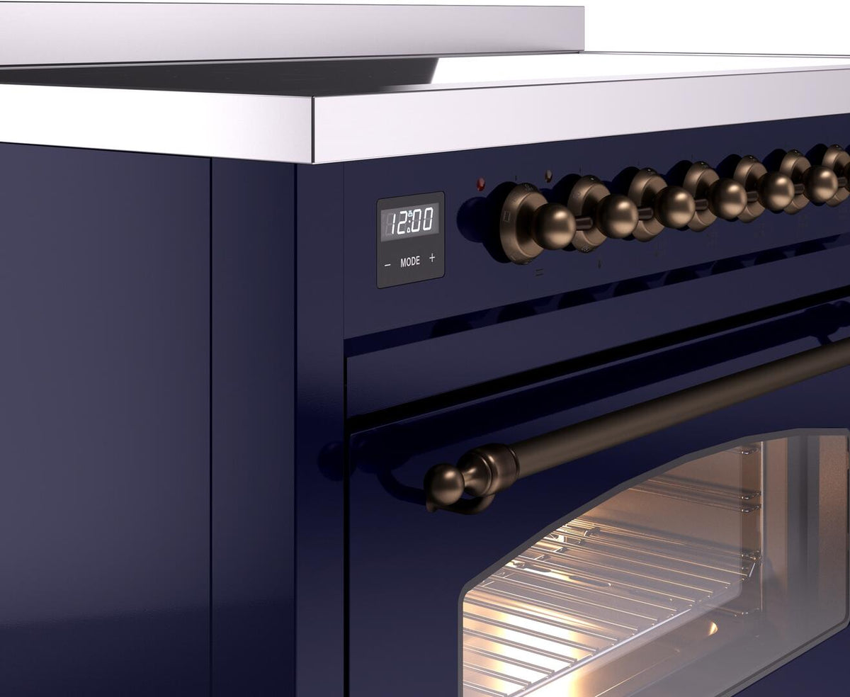 Midnight blue induction range control panel with clock display and bronze oven knobs.