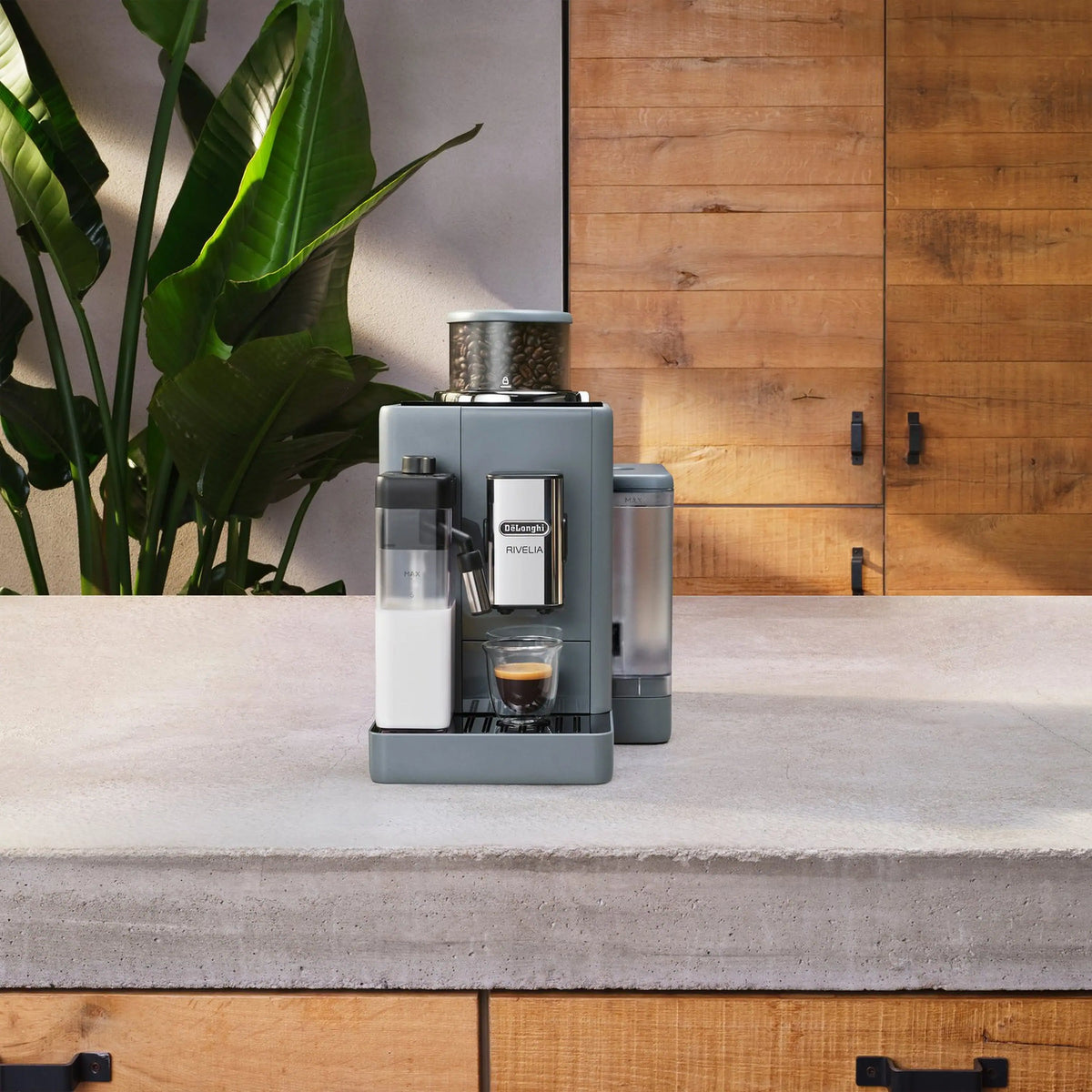 Grey and white coffee machine unit on countertop with attached carafe