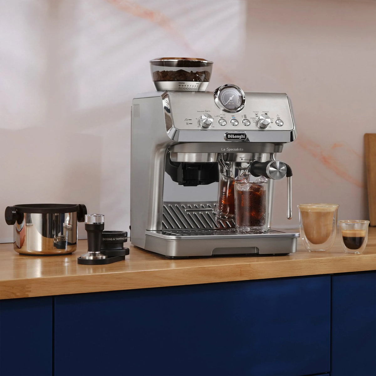 Stainless espresso machine with portafilter and cups on kitchen counter