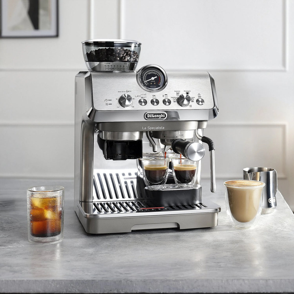 Stainless espresso machine dispensing coffee into two clear cups