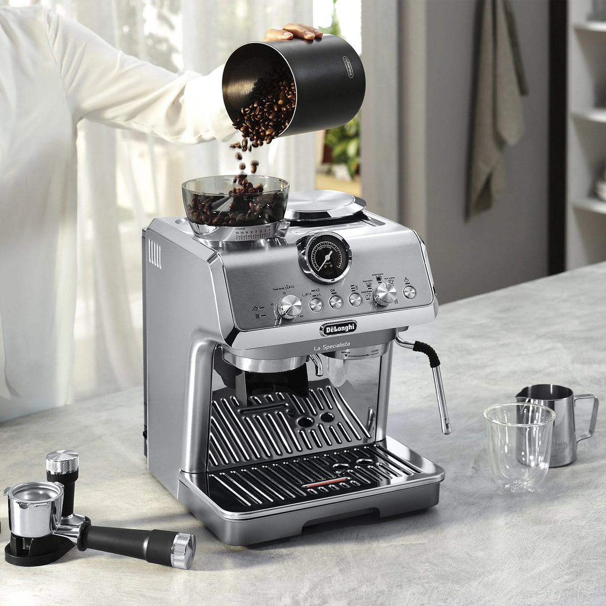 Stainless espresso machine with coffee grounds falling into hopper