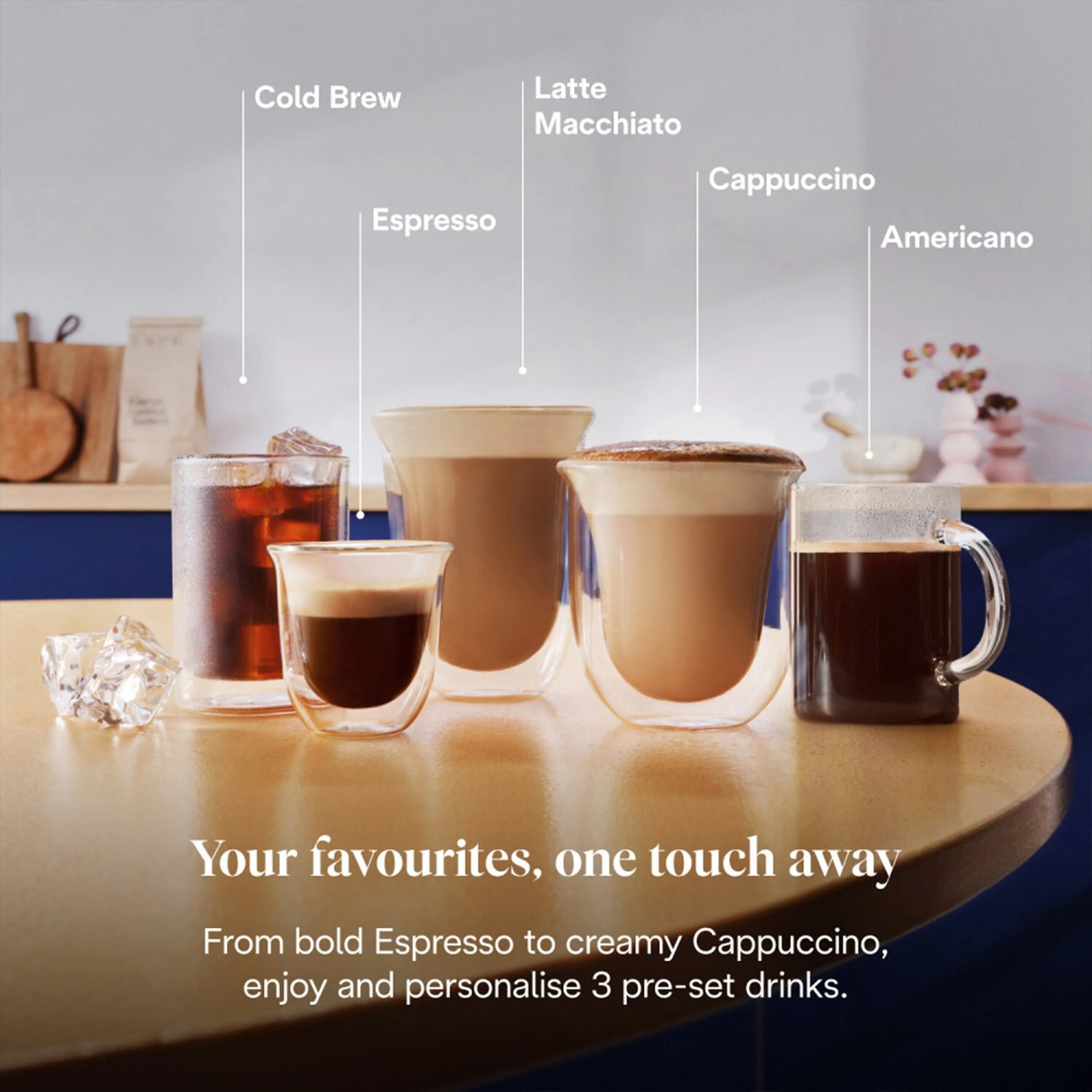 Assorted coffee cups on countertop beside a stainless espresso machine