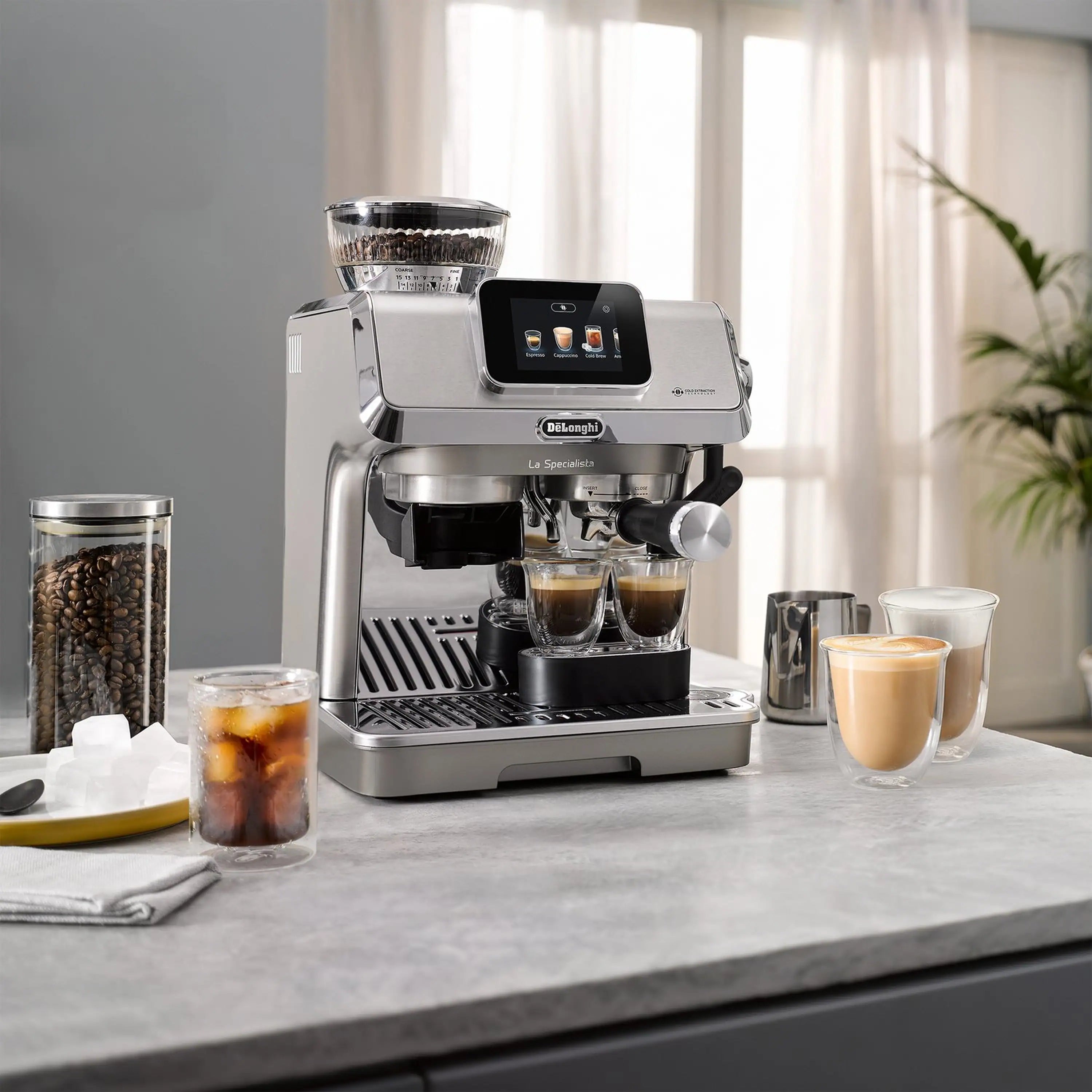 Stainless espresso machine on countertop with coffee cups and beans container