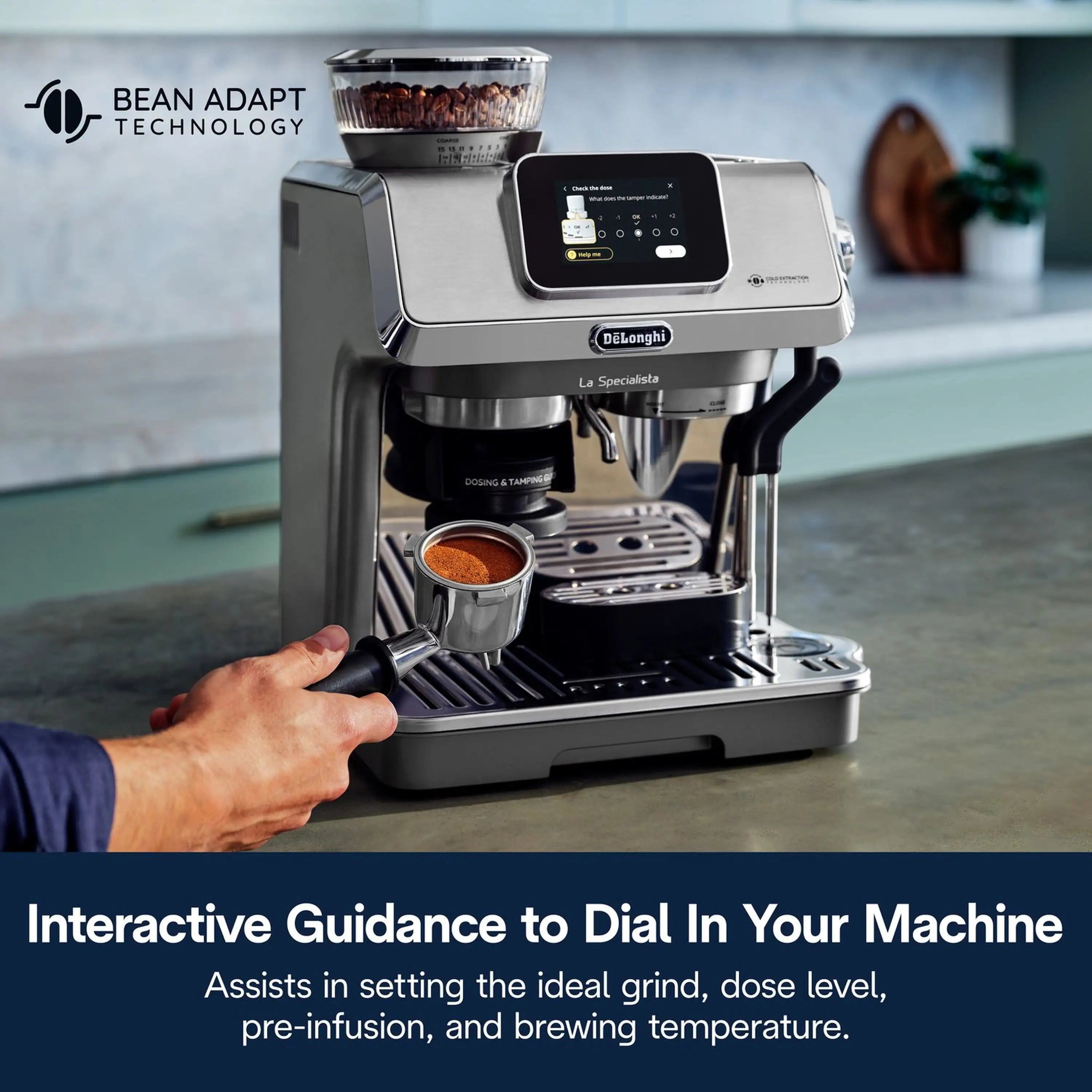 Stainless espresso machine with touchscreen and a hand holding the portafilter under the group head