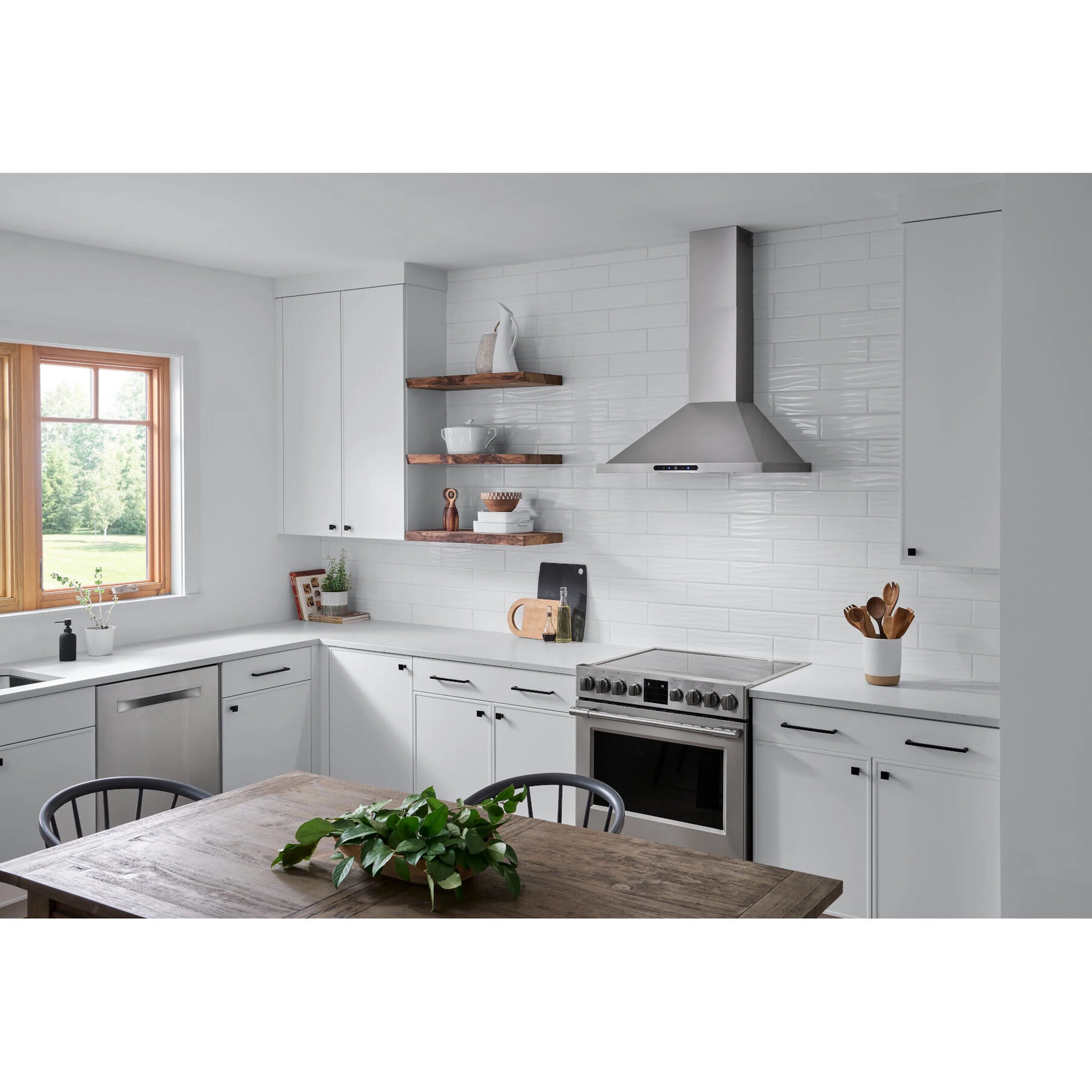 Stainless steel pyramidal chimney range hood above the cooktop in a kitchen.