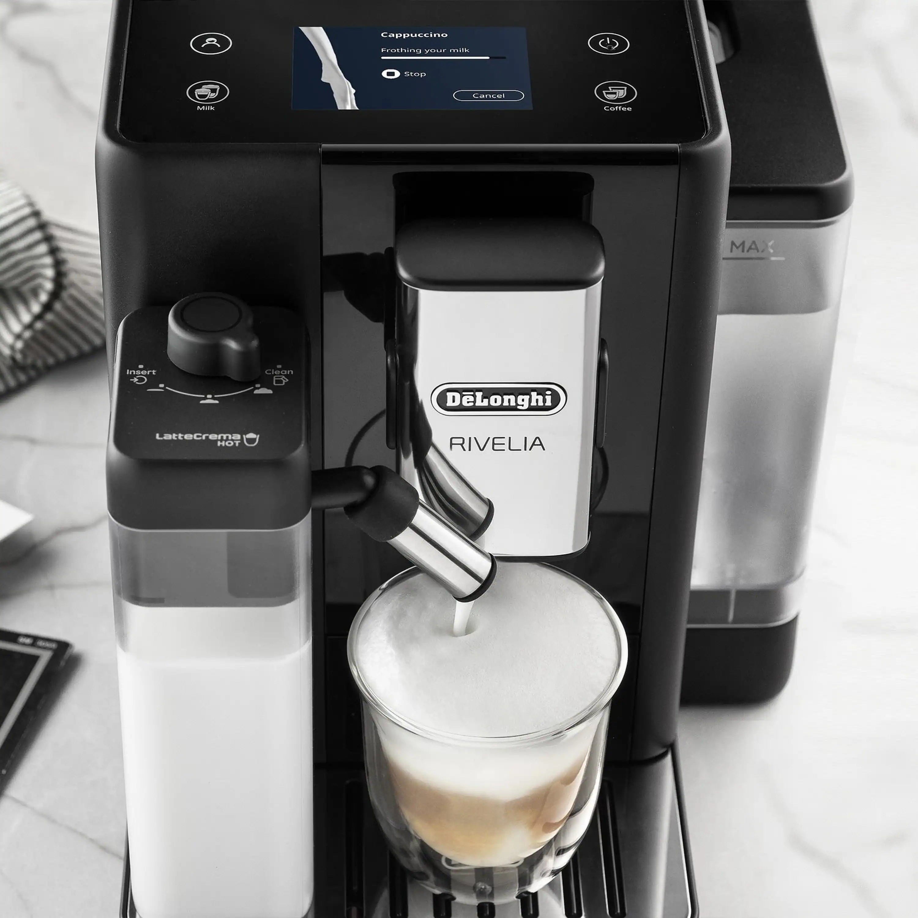 Close-up of black espresso machine dispensing into a glass cup.